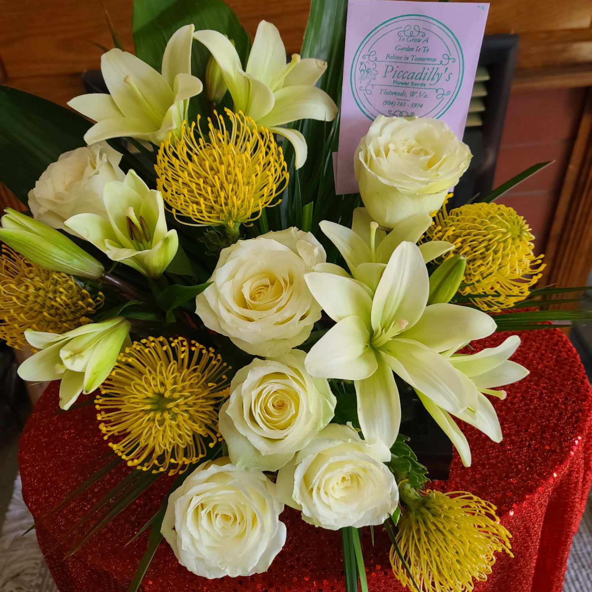Bouquet of white roses, lilies, and yellow pincushion blooms