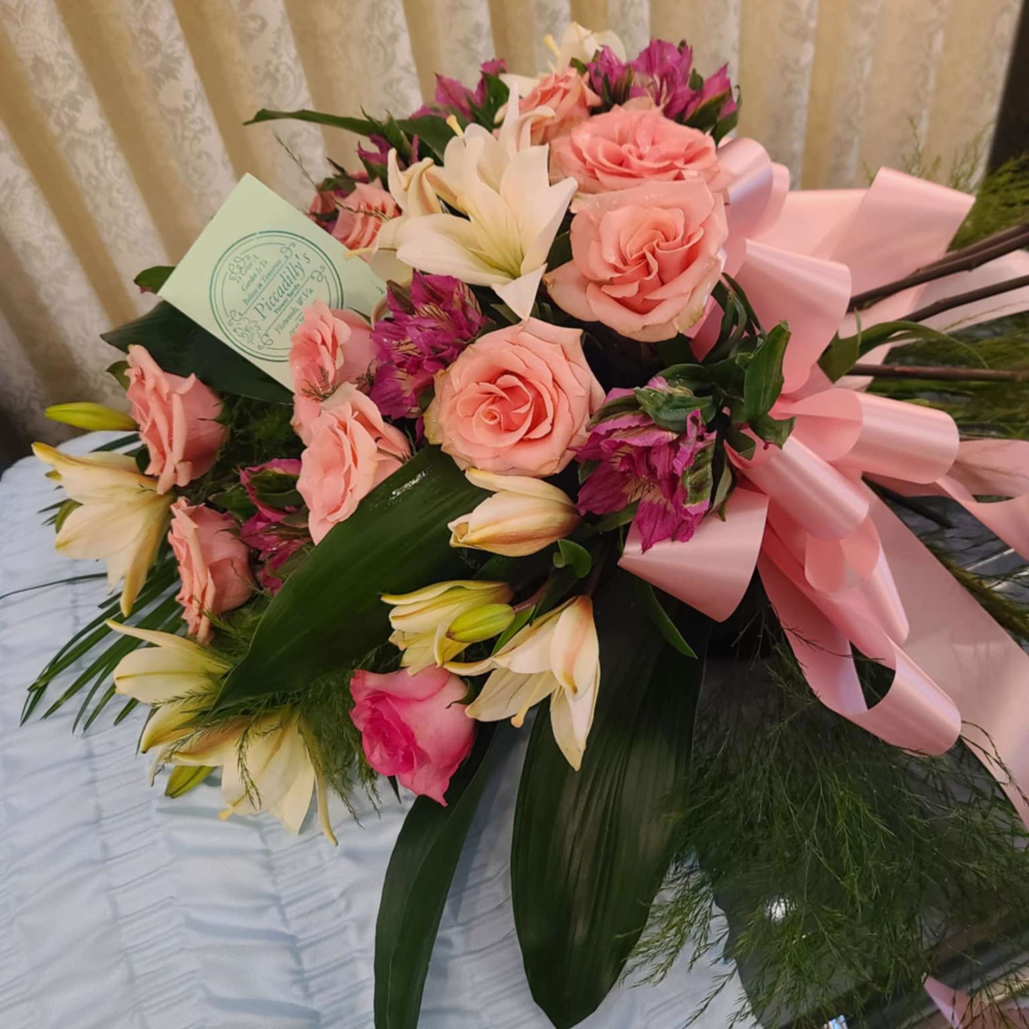 Bouquet of pink roses and white lilies with a pink ribbon