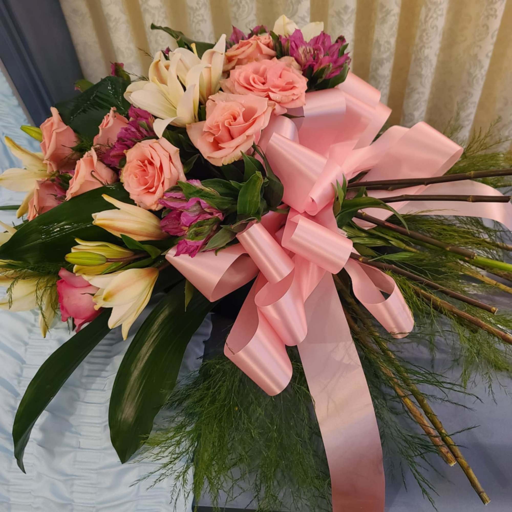 Pink rose and lily bouquet with a large pink ribbon