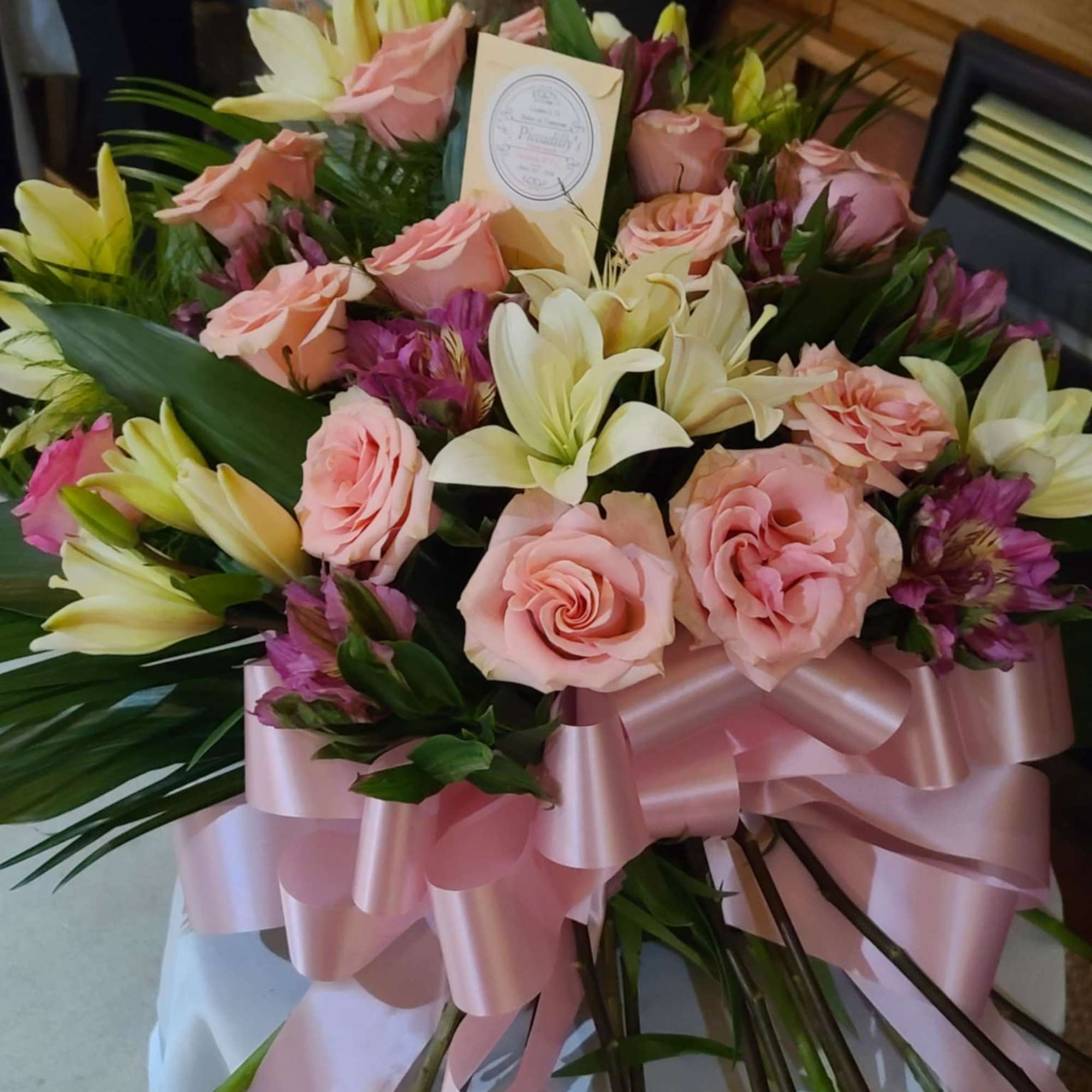 Pink and cream rose bouquet with lilies and a satin ribbon