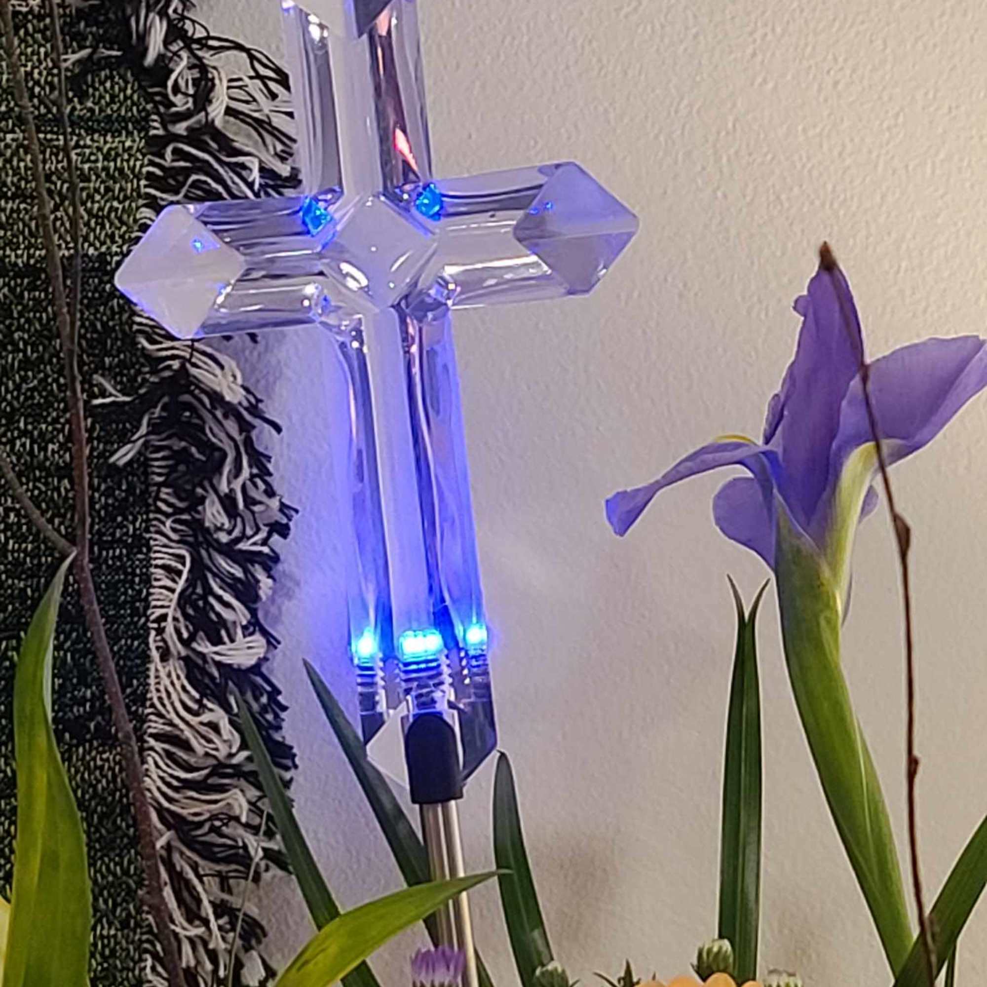 Purple flowers with a clear illuminated cross ornament