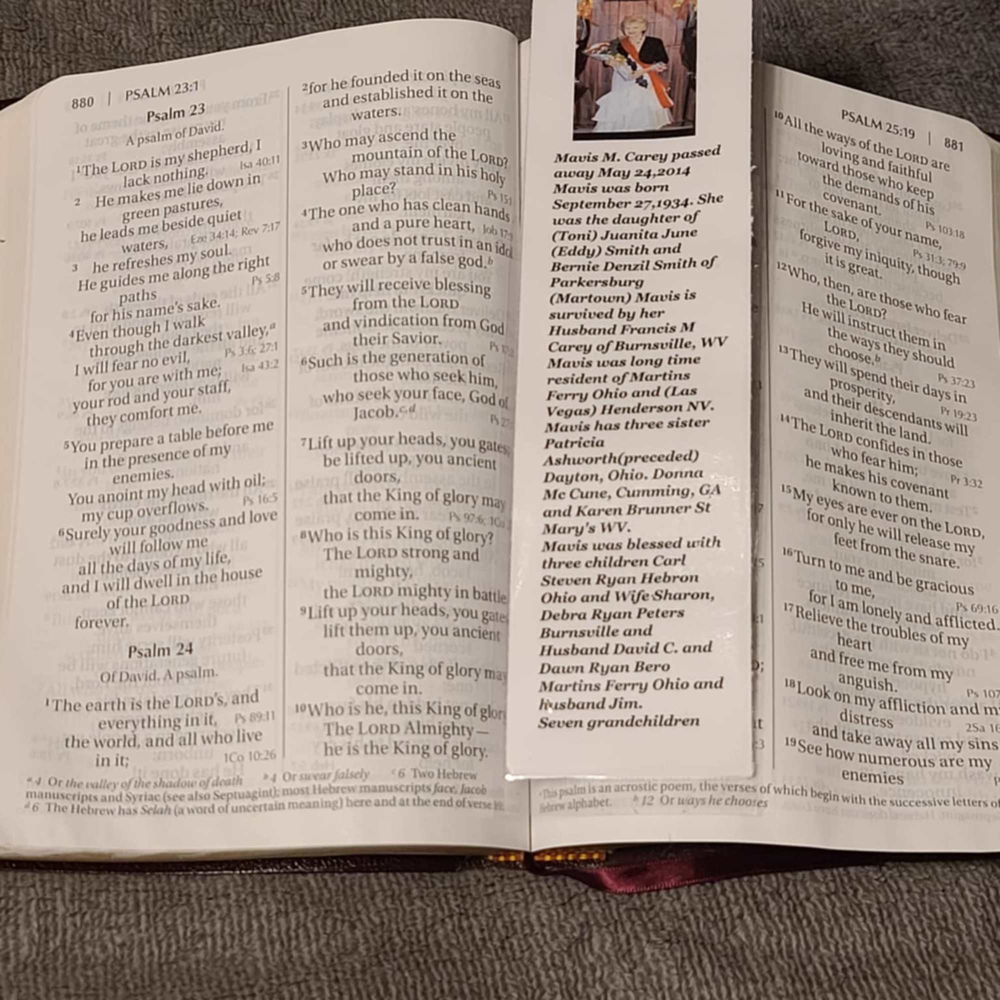 Bible open to Psalms with a memorial bookmark laid across the pages