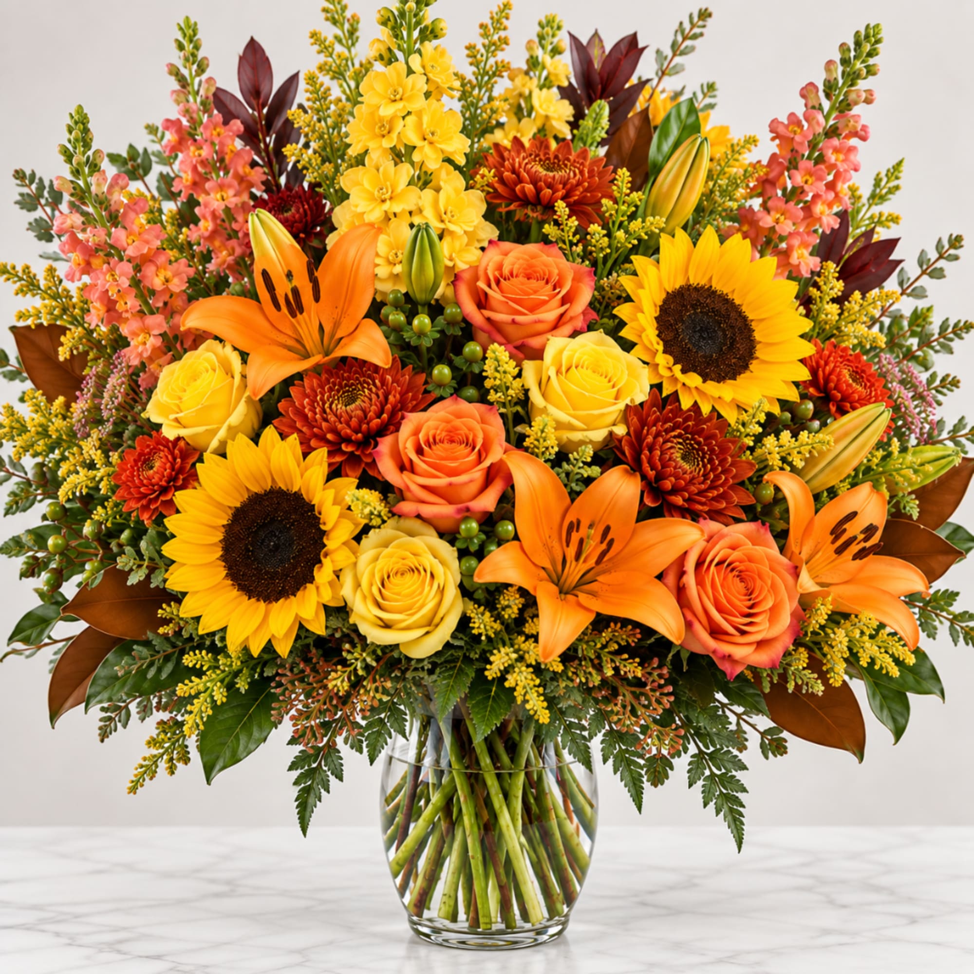 Bright mixed bouquet with sunflowers, roses, lilies, and chrysanthemums in a glass vase