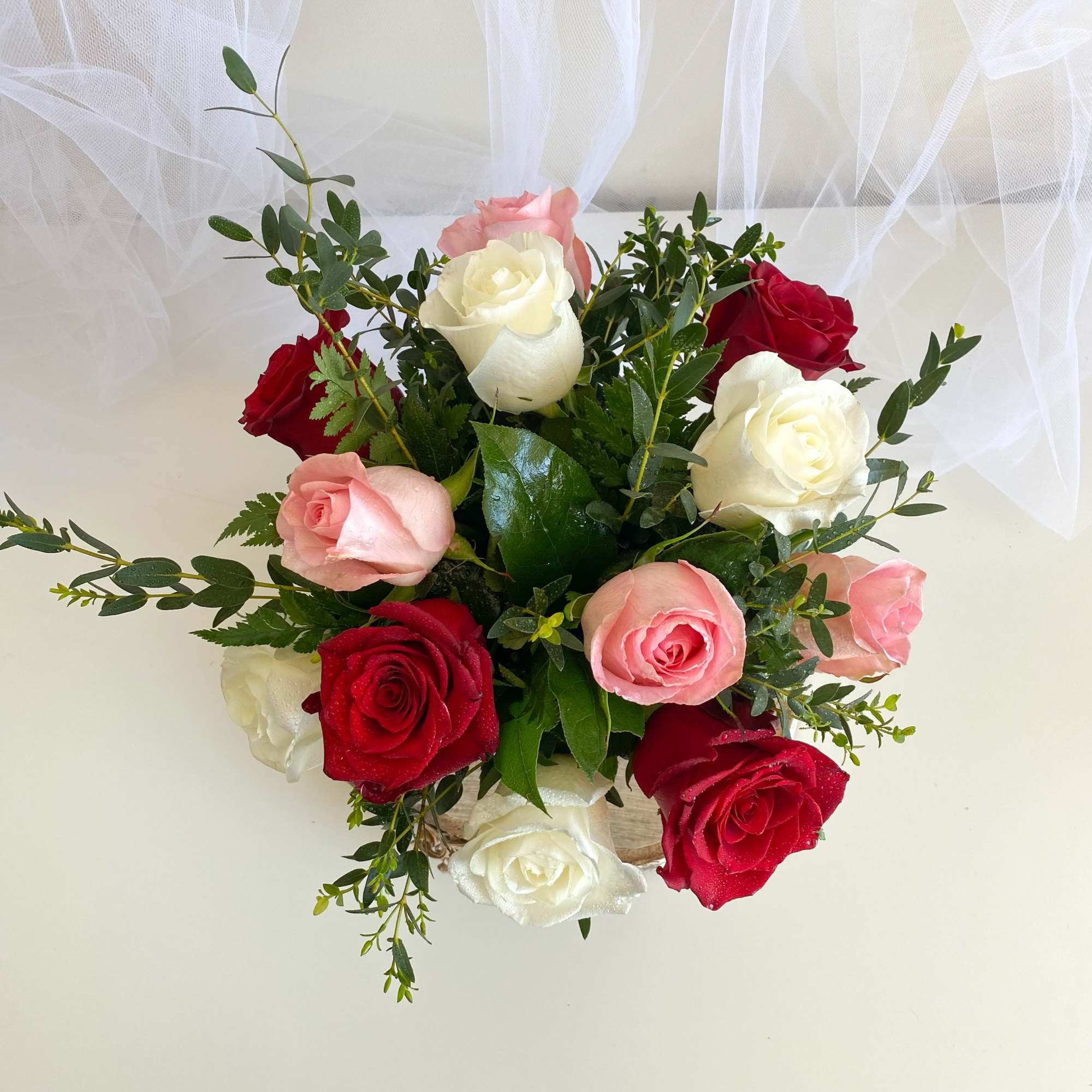 Bouquet of red, white, and pink roses with greenery