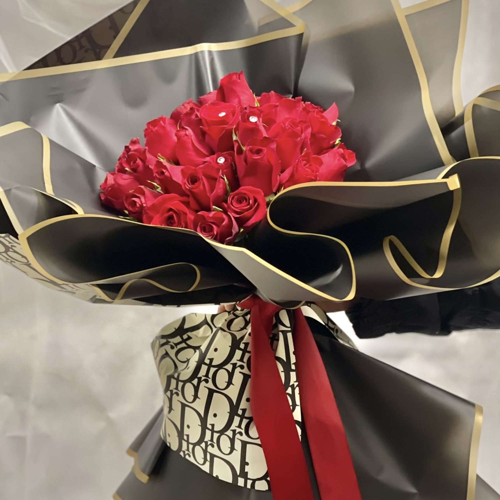 Bouquet of red roses wrapped in black and gold paper
