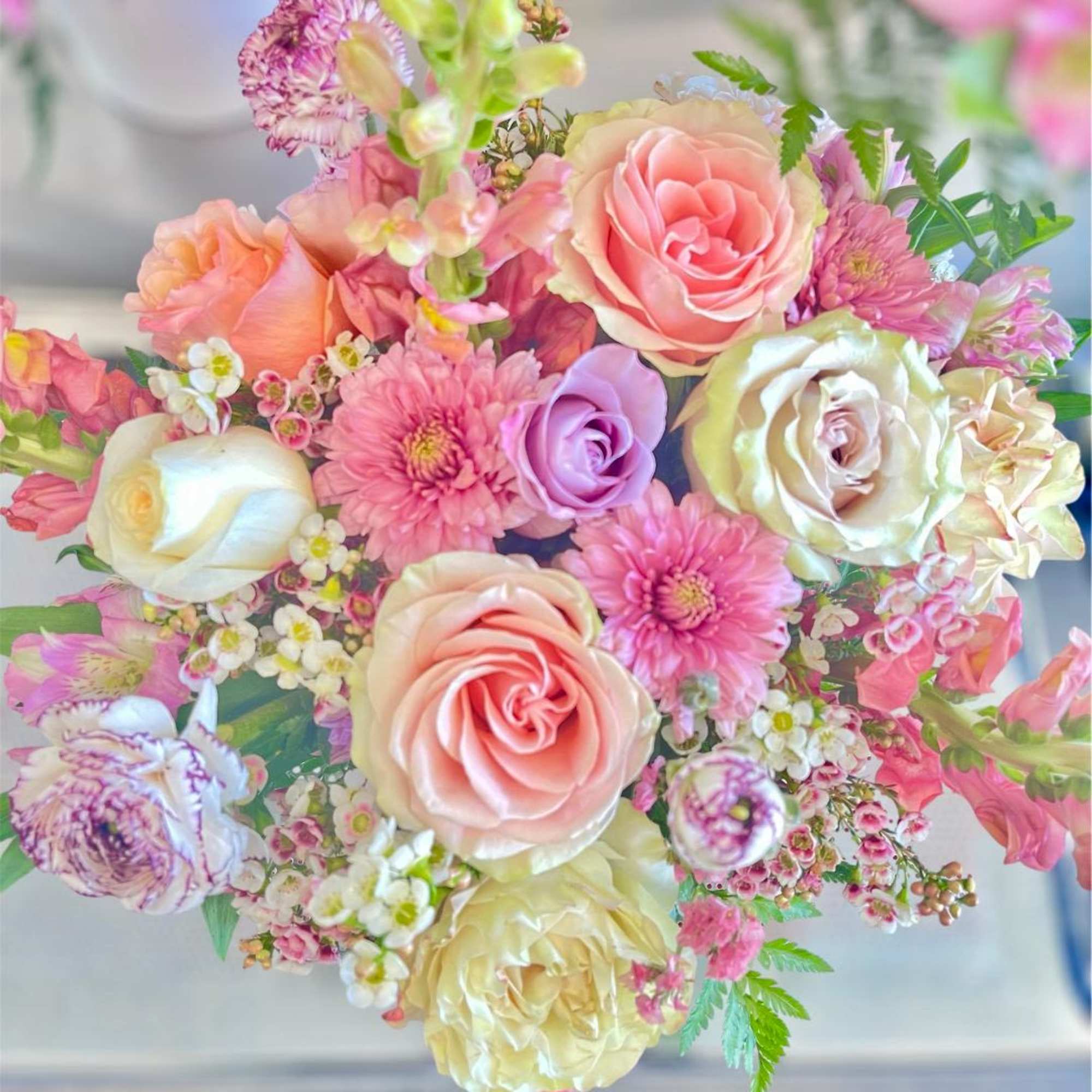 Pastel bouquet of roses and pink daisies with small filler flowers