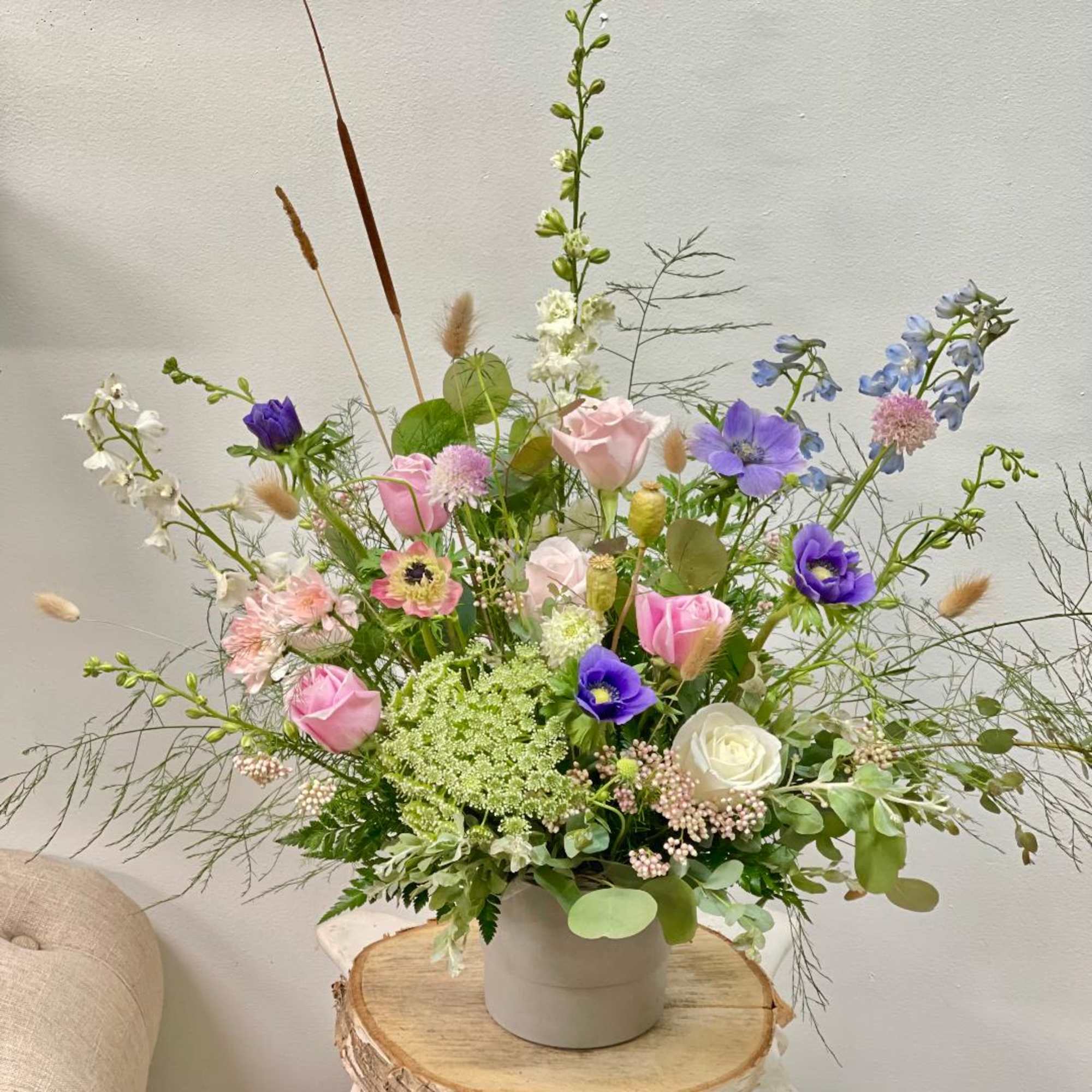 Loose pastel bouquet in a white vase with pink, purple, and white blooms