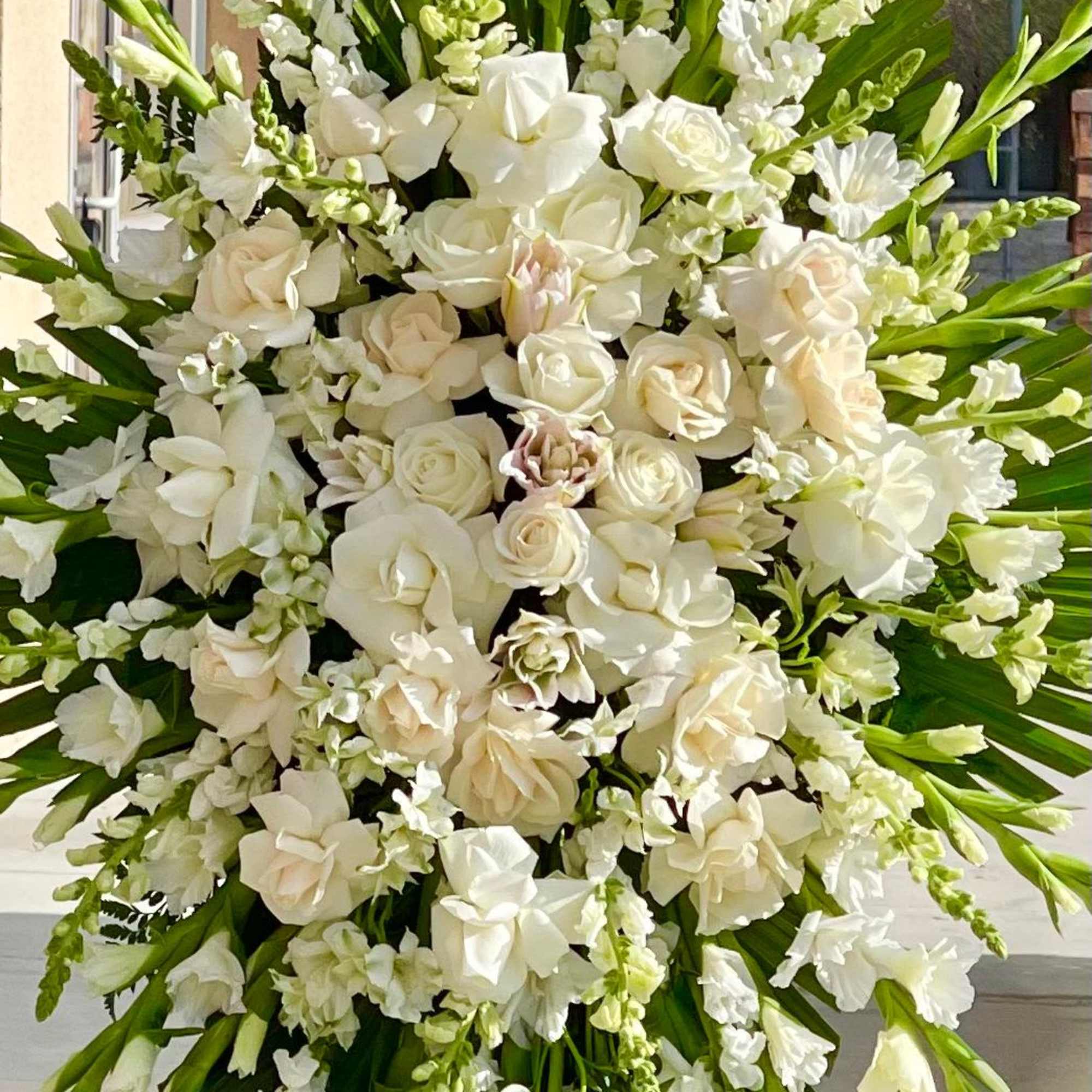 Large white floral standing spray with roses and lilies