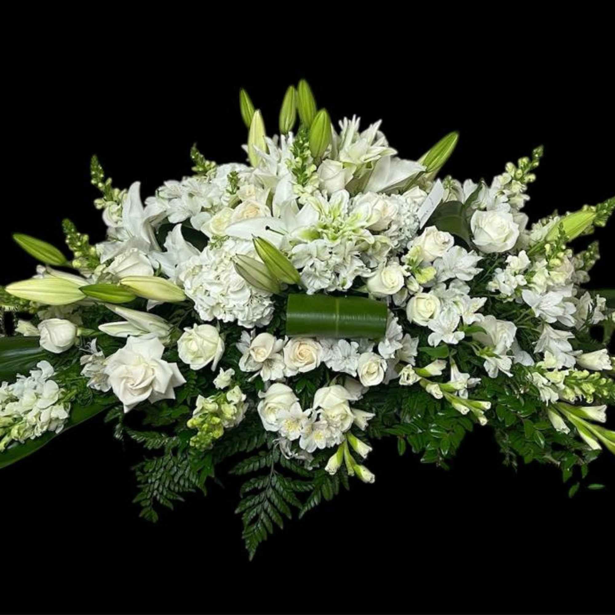 White floral casket spray with lilies and roses