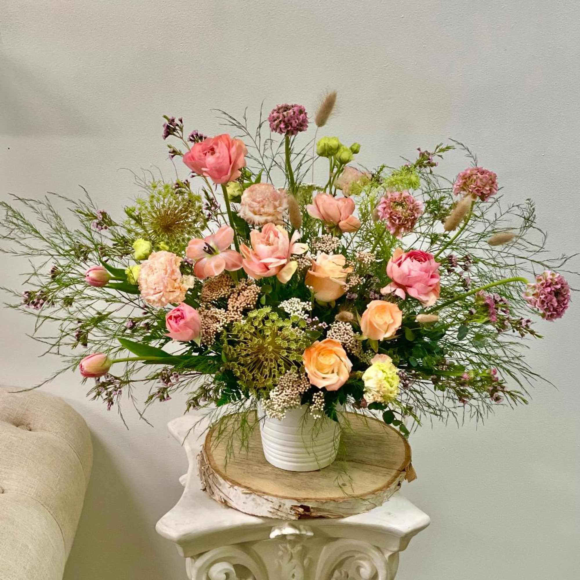 Pink and peach flower arrangement in a white vase