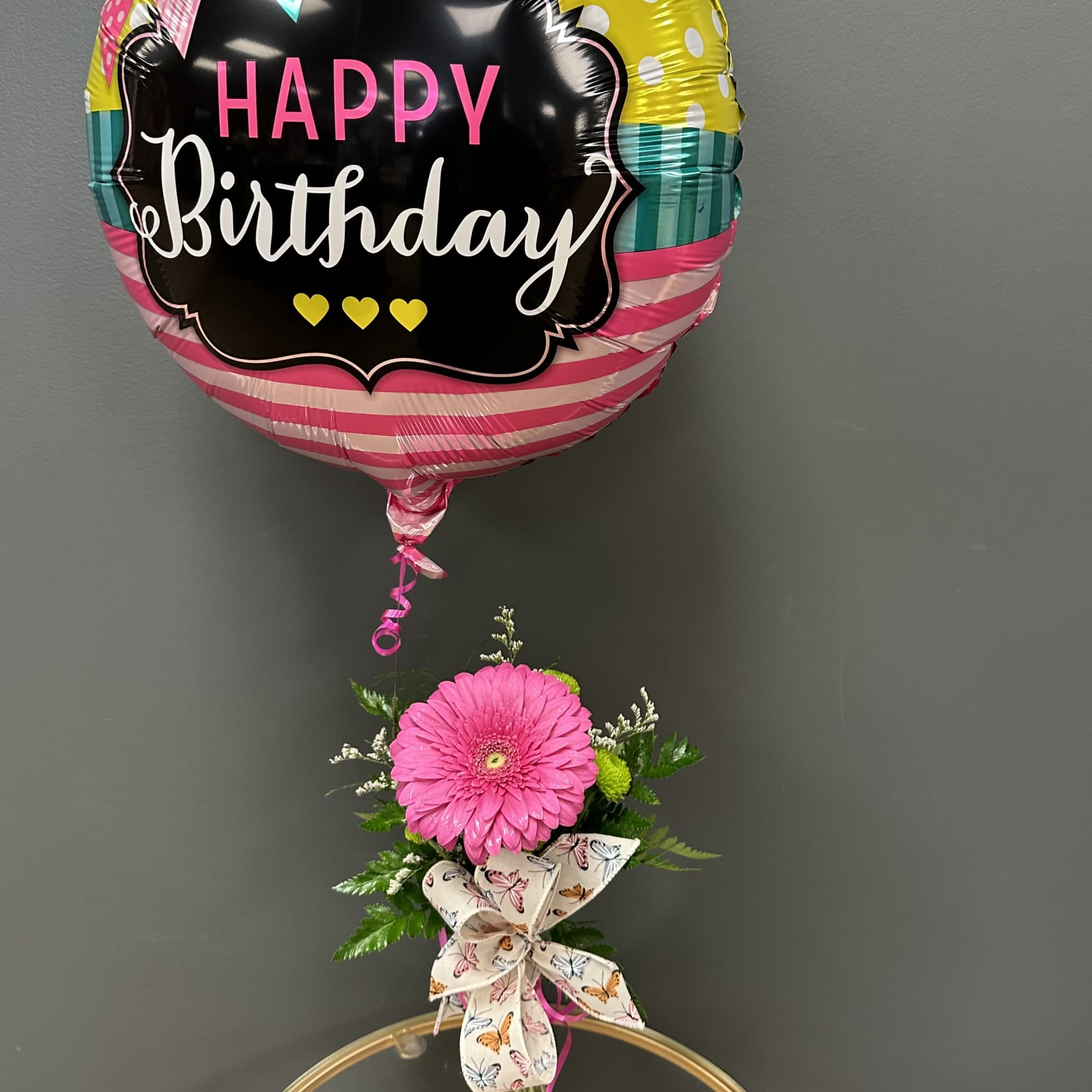 Birthday balloon above a pink gerbera in a glass vase