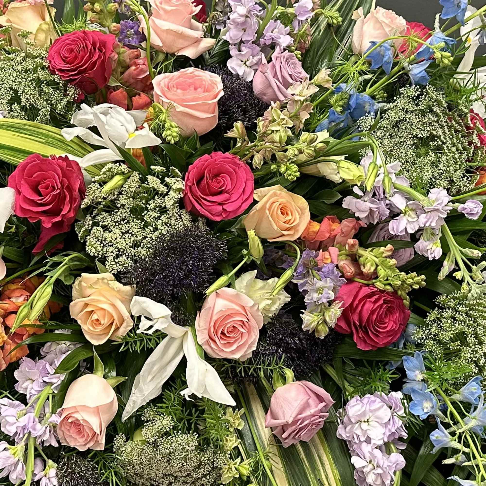Mixed bouquet of roses and pastel flowers on a dark background