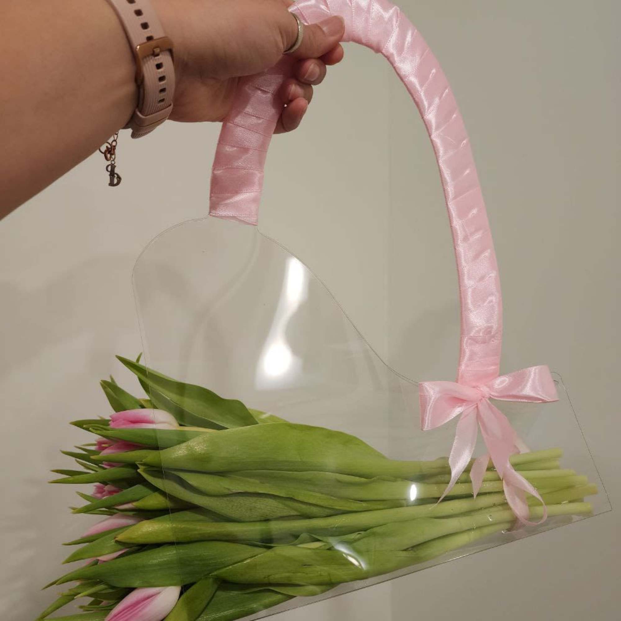 Pink tulips in a clear handbag-style wrap with a pink ribbon handle