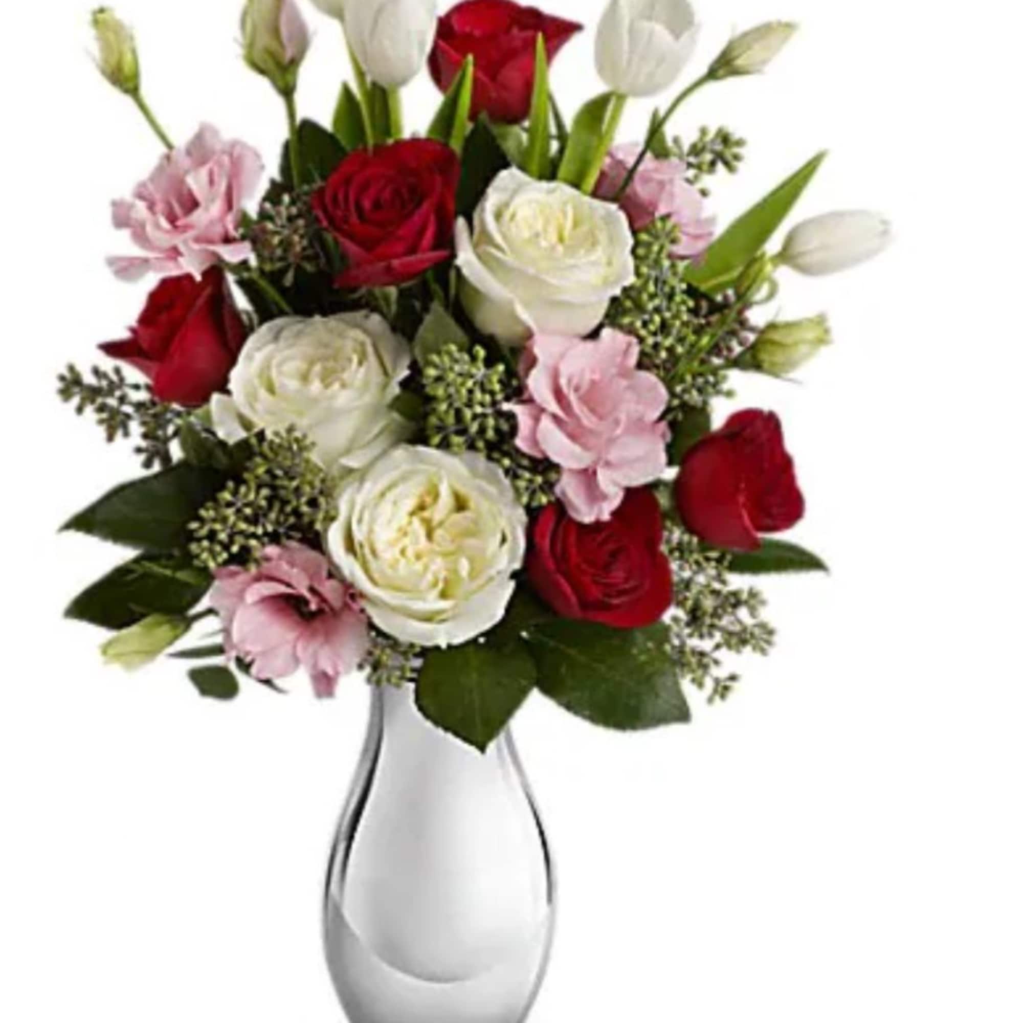 Bouquet of red and white roses with pink blooms in a clear glass vase