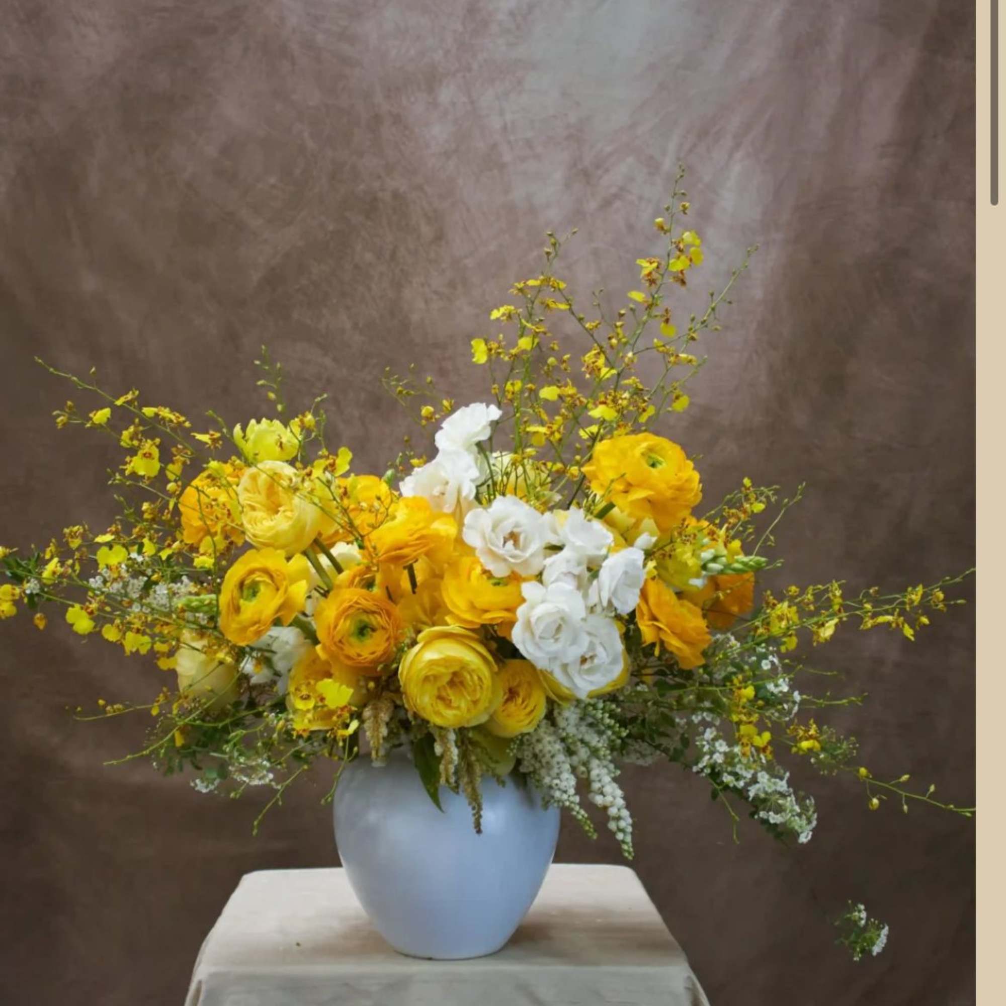 Yellow and white flowers arranged in a white vase