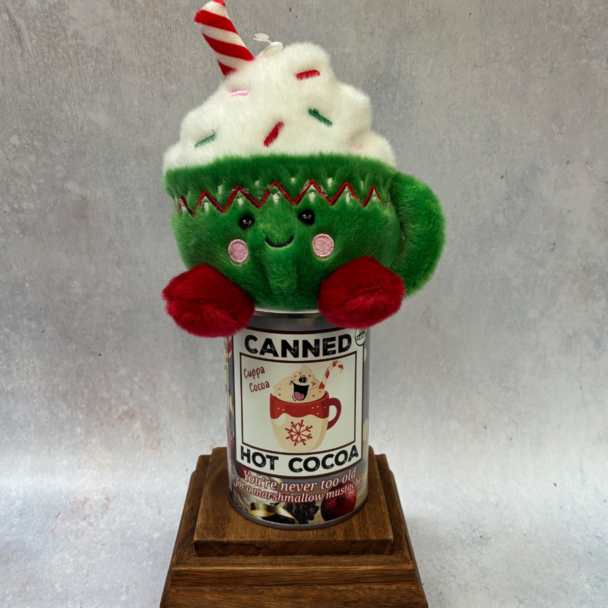 Plush Christmas cup topper on a hot cocoa can