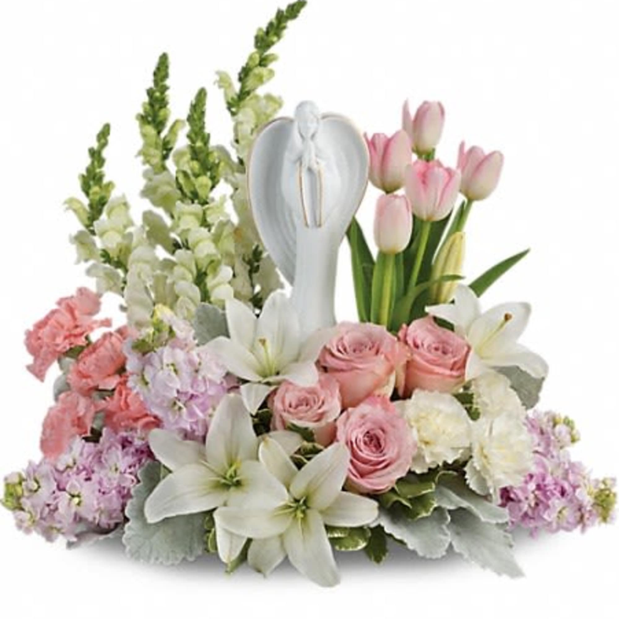 Pastel arrangement of white lilies, pink roses and tulips surrounding a white angel figurine.