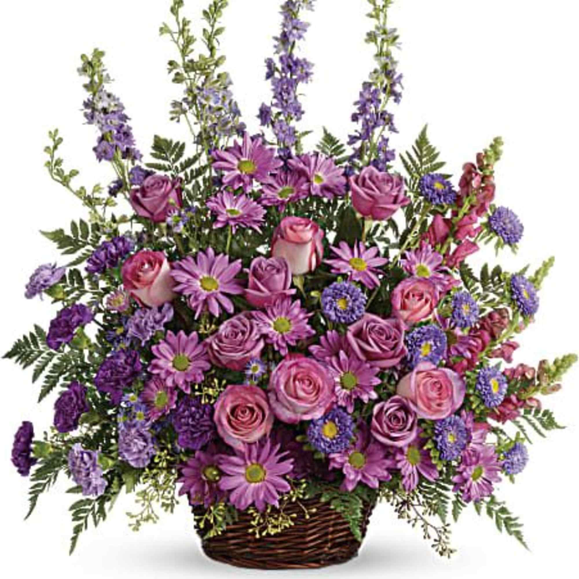 Tall basket arrangement of pink roses, daisies, carnations, and purple asters with vertical delphinium spikes