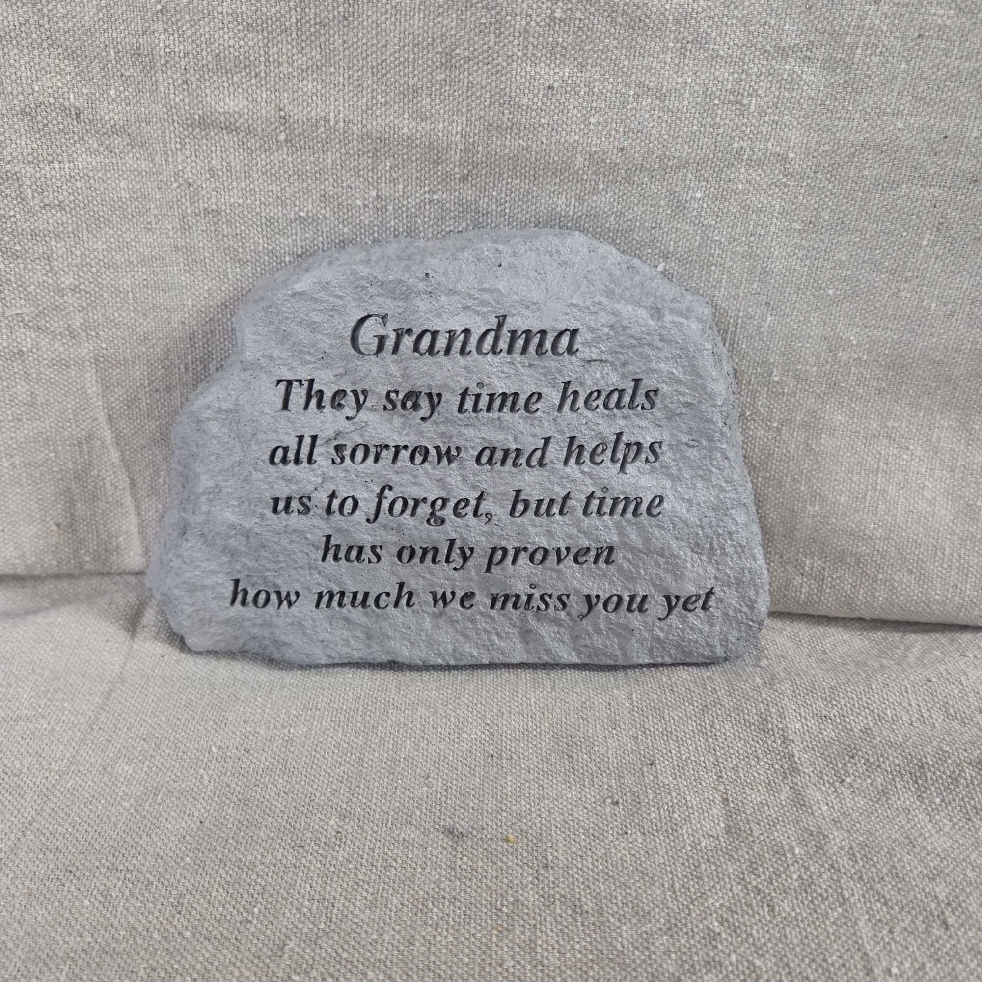 Gray memorial stone for Grandma with engraved verse on a neutral fabric background