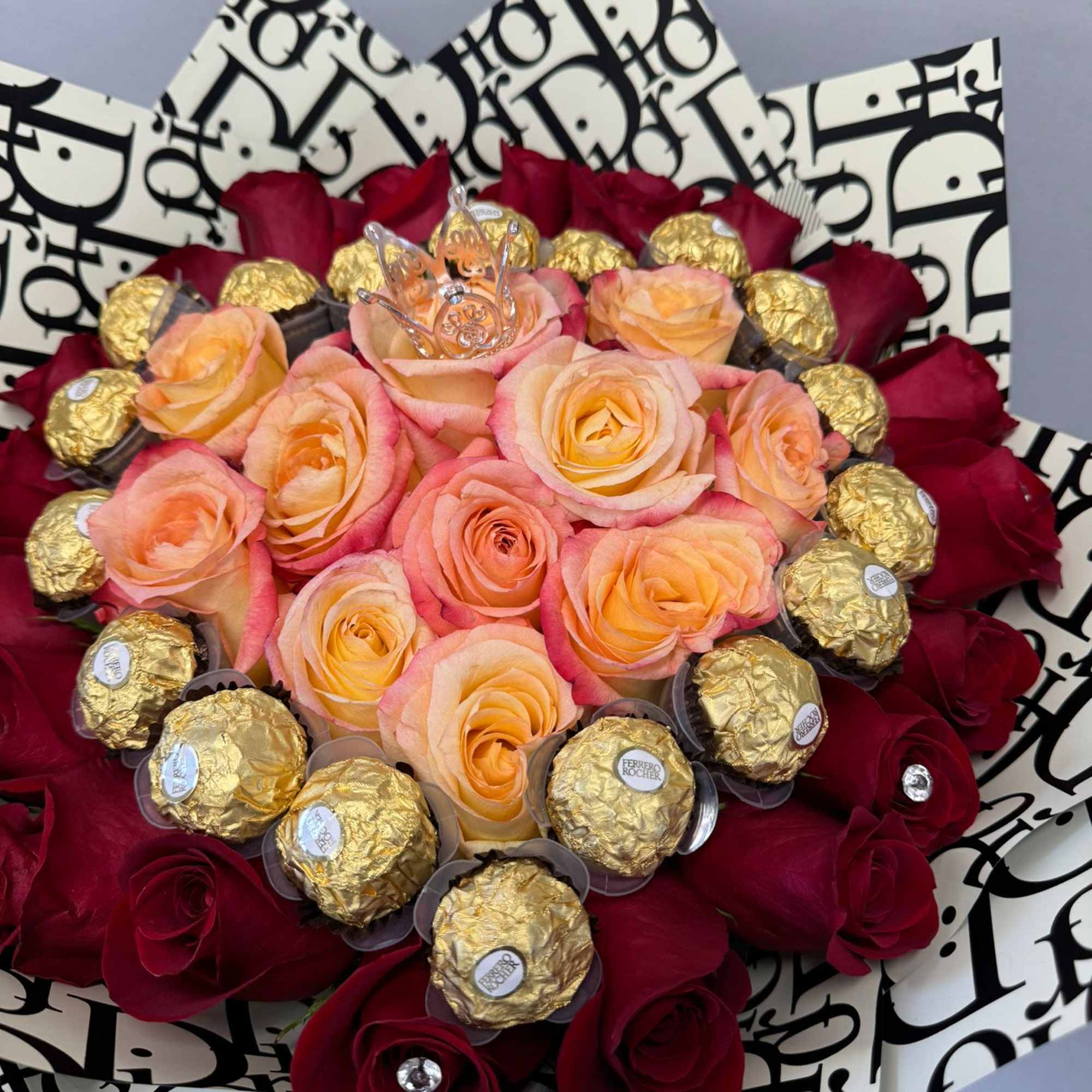 Bouquet of peach and red roses with gold-wrapped chocolates