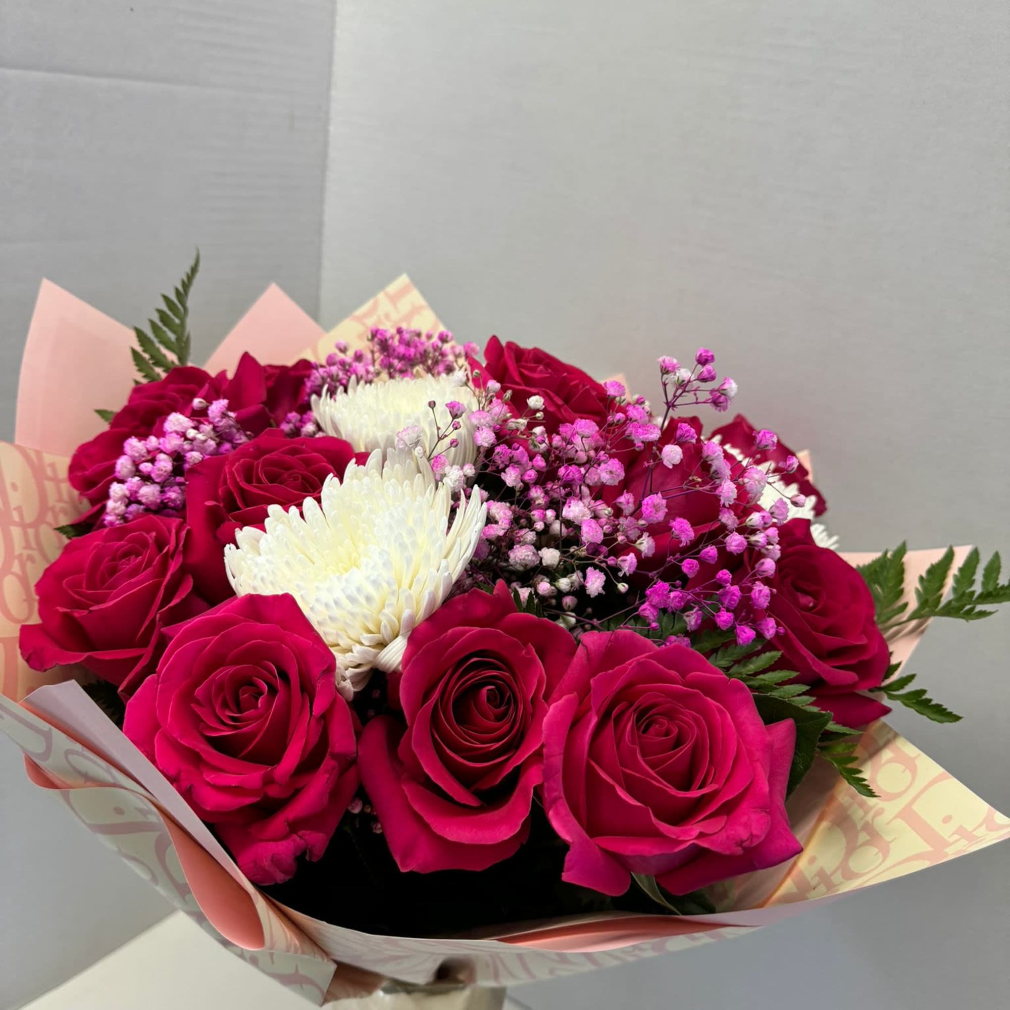 Bouquet of hot pink roses with white chrysanthemum blooms and pink baby's breath