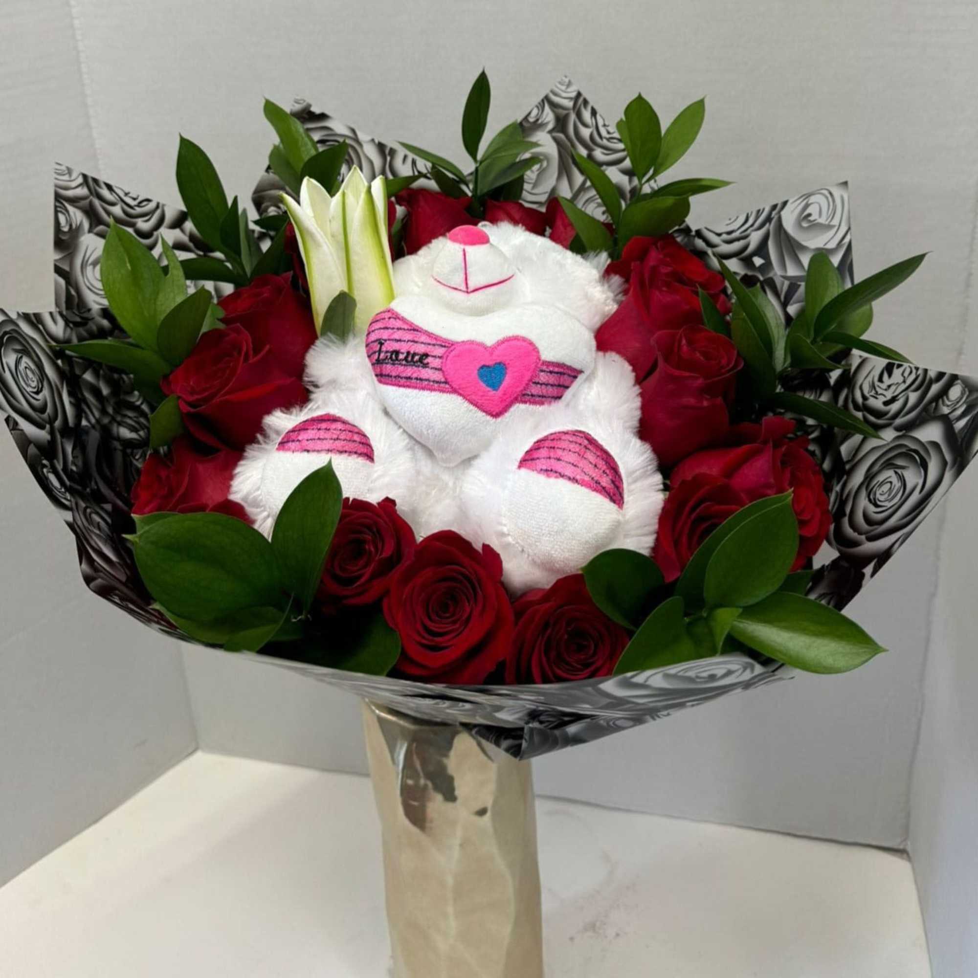 Bouquet of red roses with a white teddy bear in the center