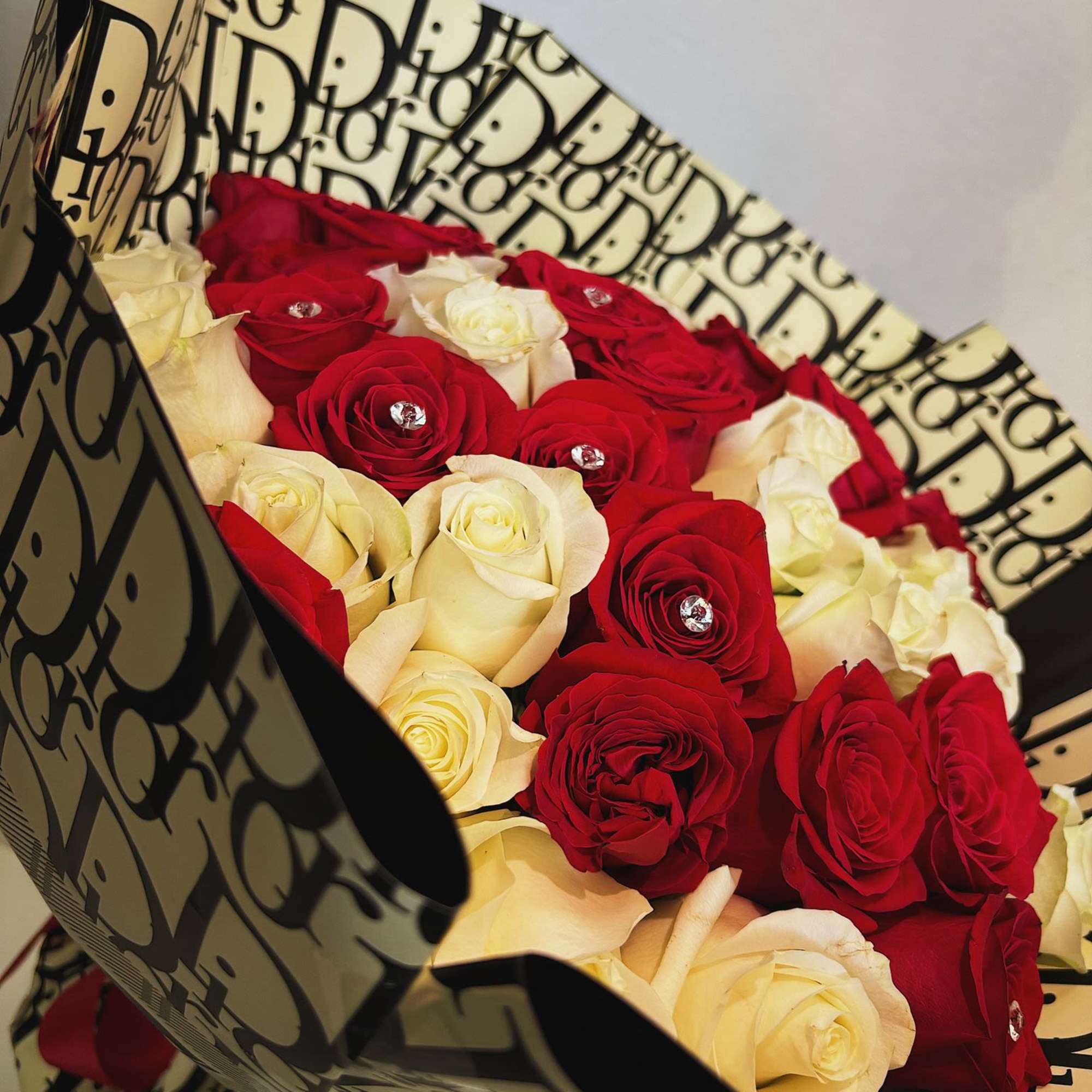 Bouquet of red and white roses wrapped in patterned paper