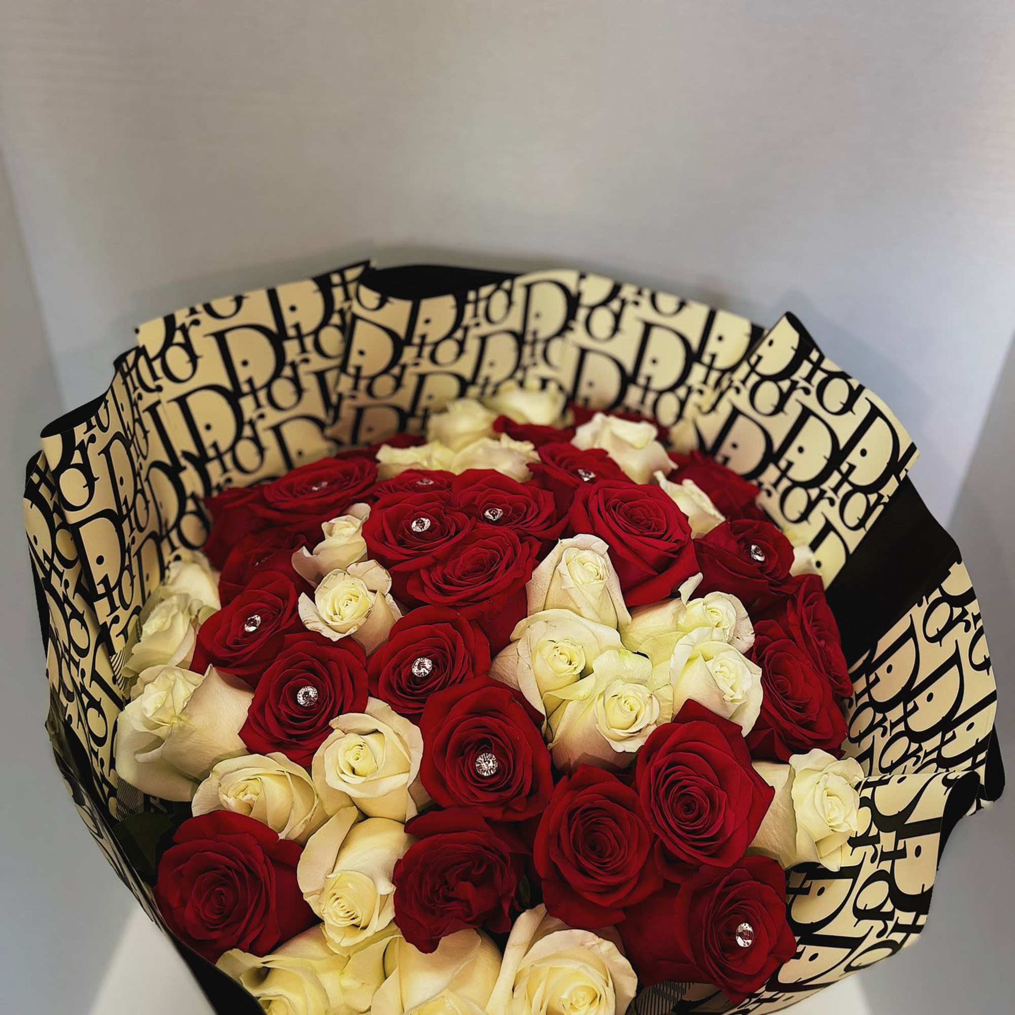 Bouquet of red and cream roses in patterned wrapping