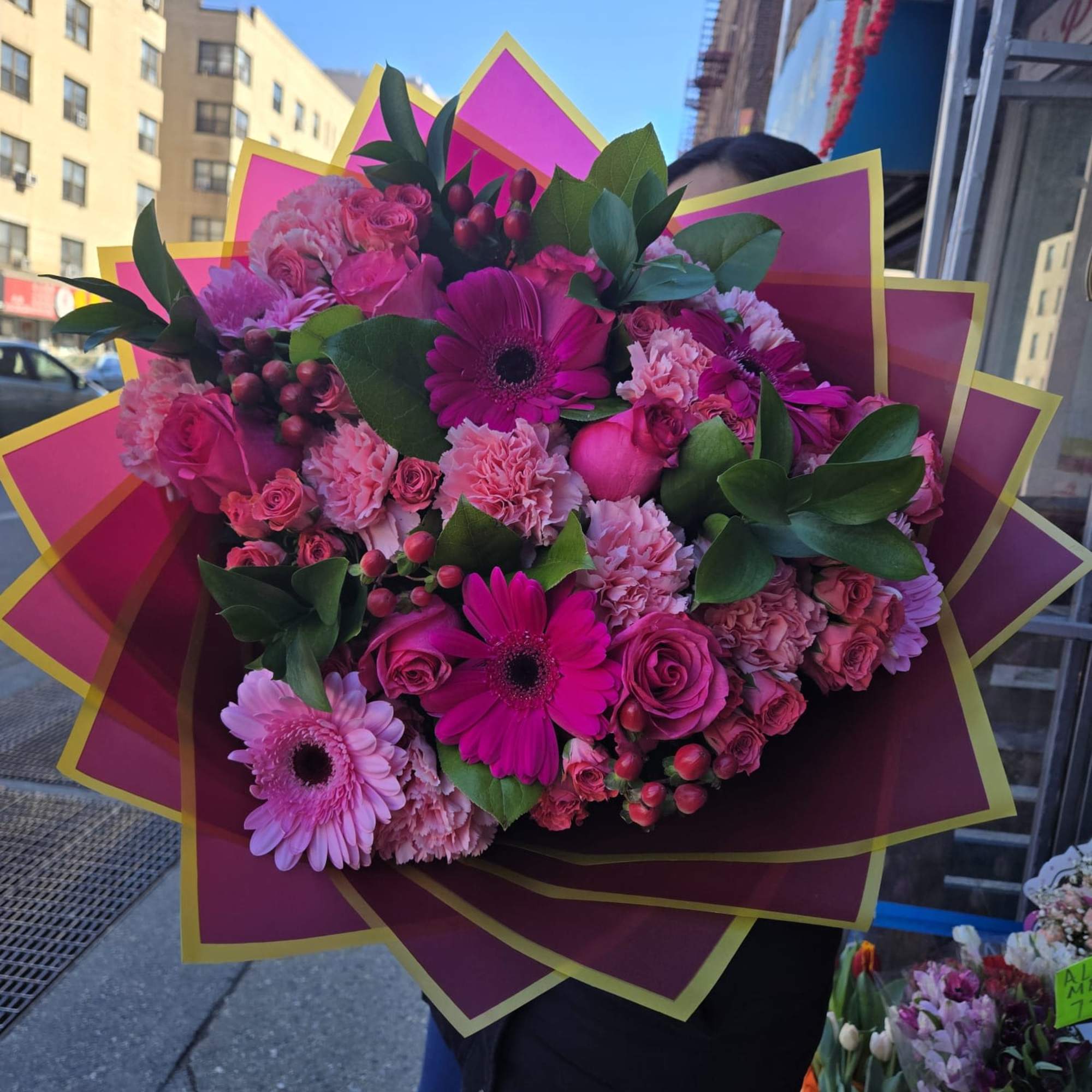 Large pink bouquet with gerbera daisies, roses, and carnations wrapped in magenta paper