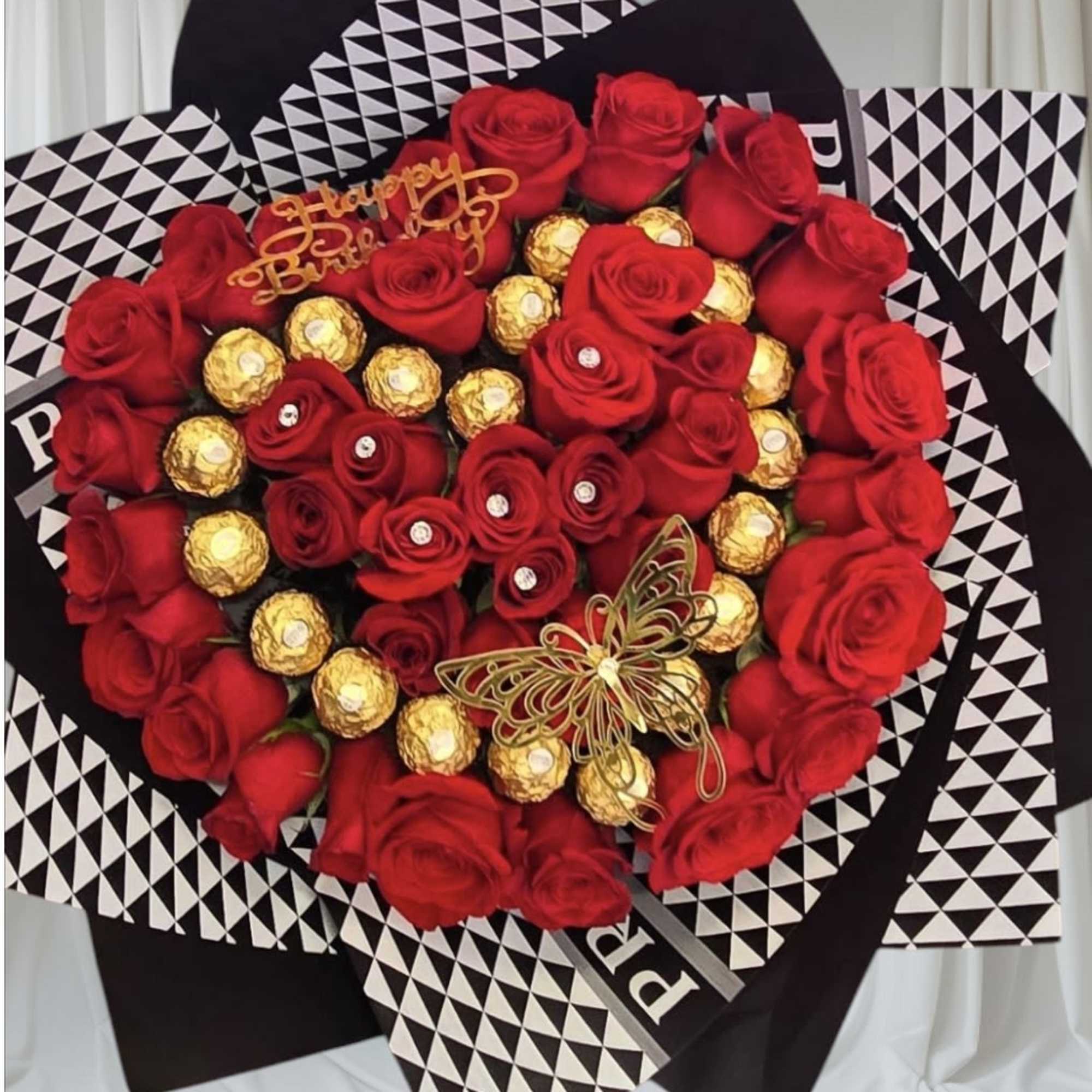 Heart-shaped bouquet of red roses and gold-wrapped chocolates