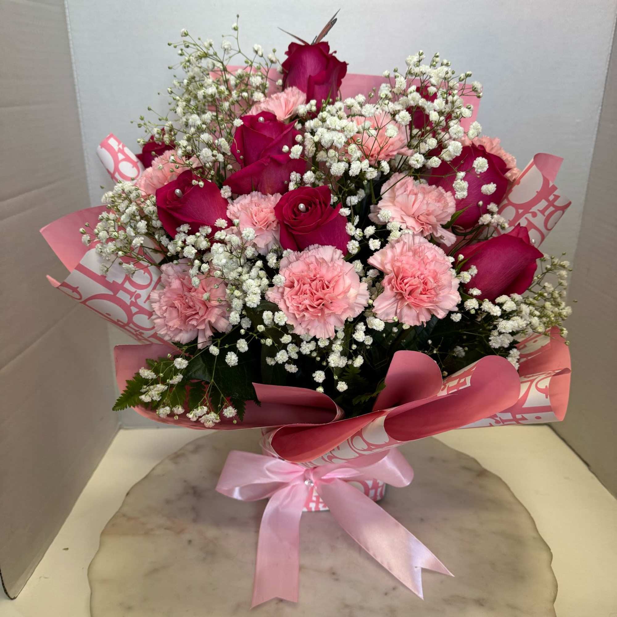hot pink roses, pink carnations, baby's breath all in a piece of
