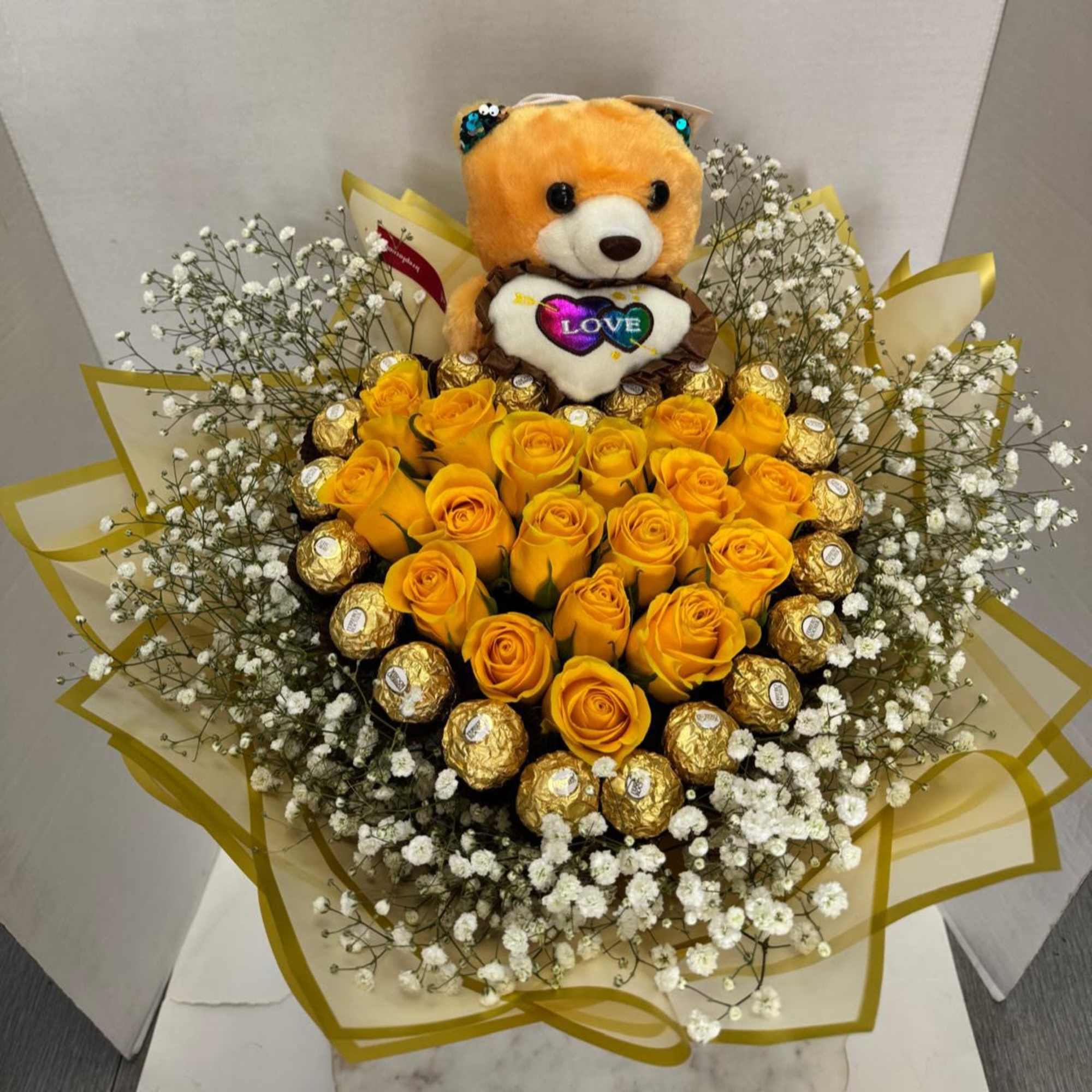 Bouquet of yellow roses with a teddy bear and chocolates