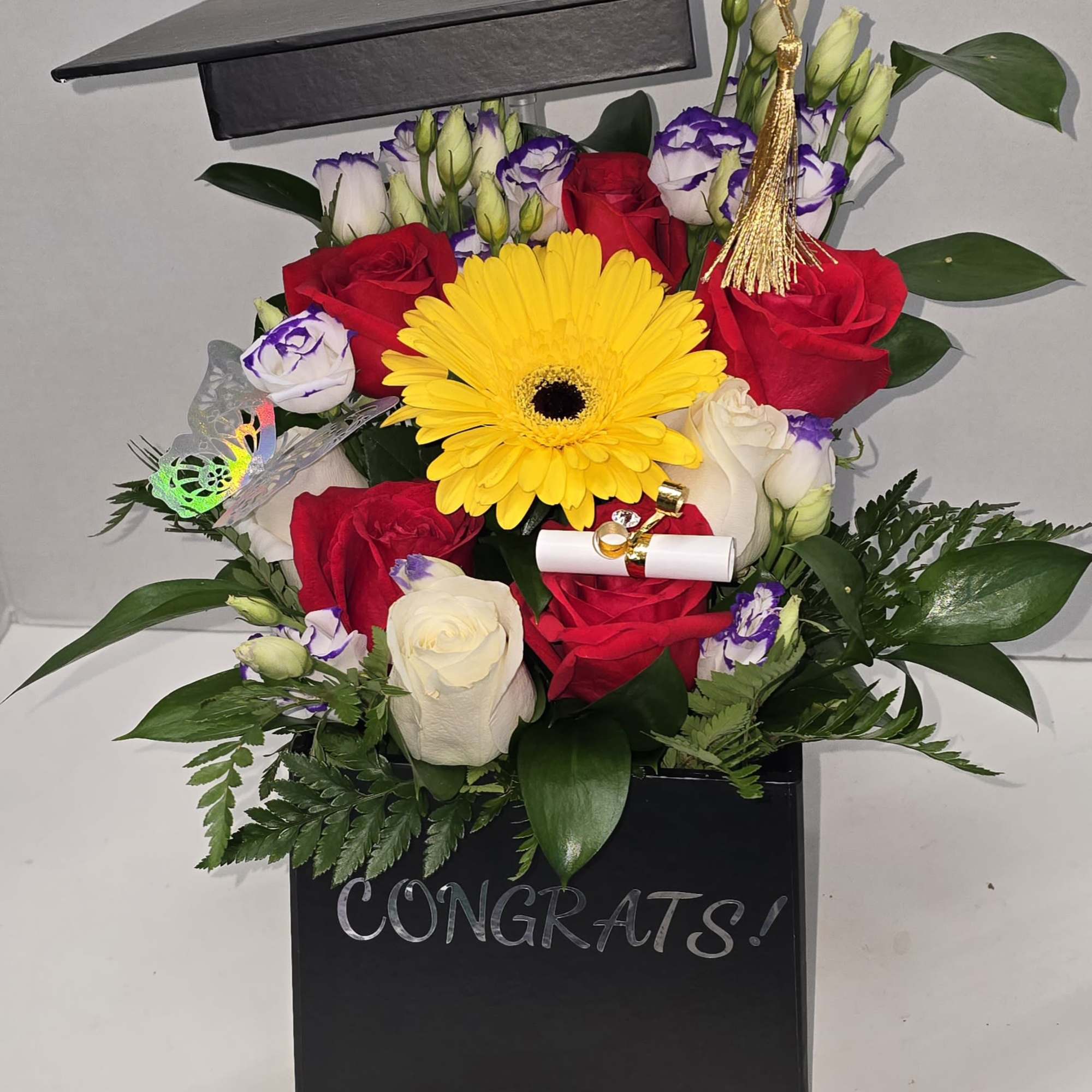 Graduation bouquet in a black box with roses and a yellow gerbera daisy