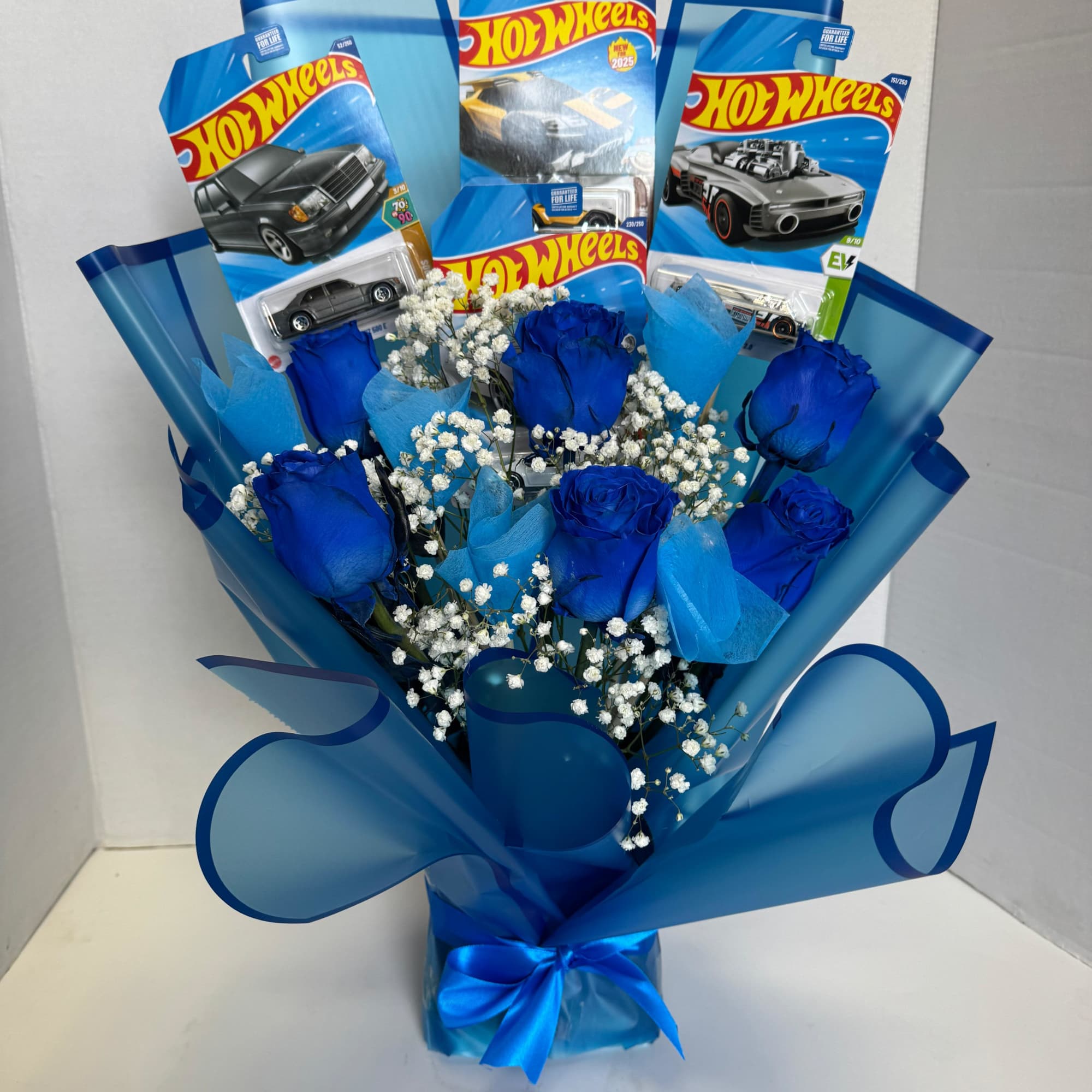 Blue rose bouquet with Hot Wheels toy car packages and a satin ribbon