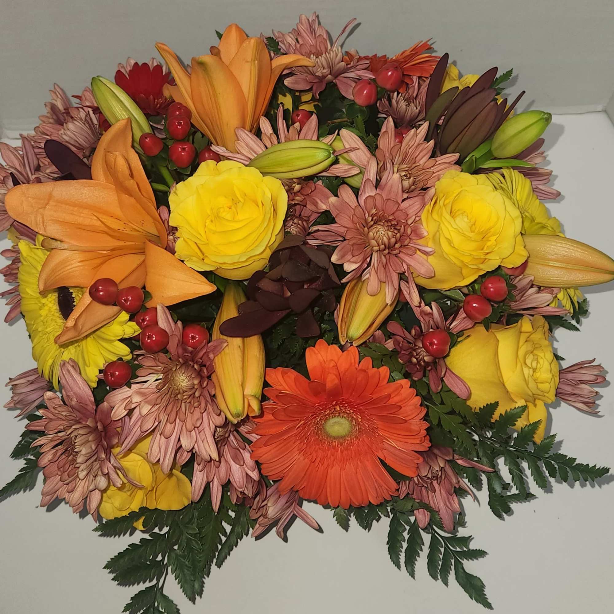 Mixed bouquet with yellow roses, orange lilies, and an orange gerbera daisy