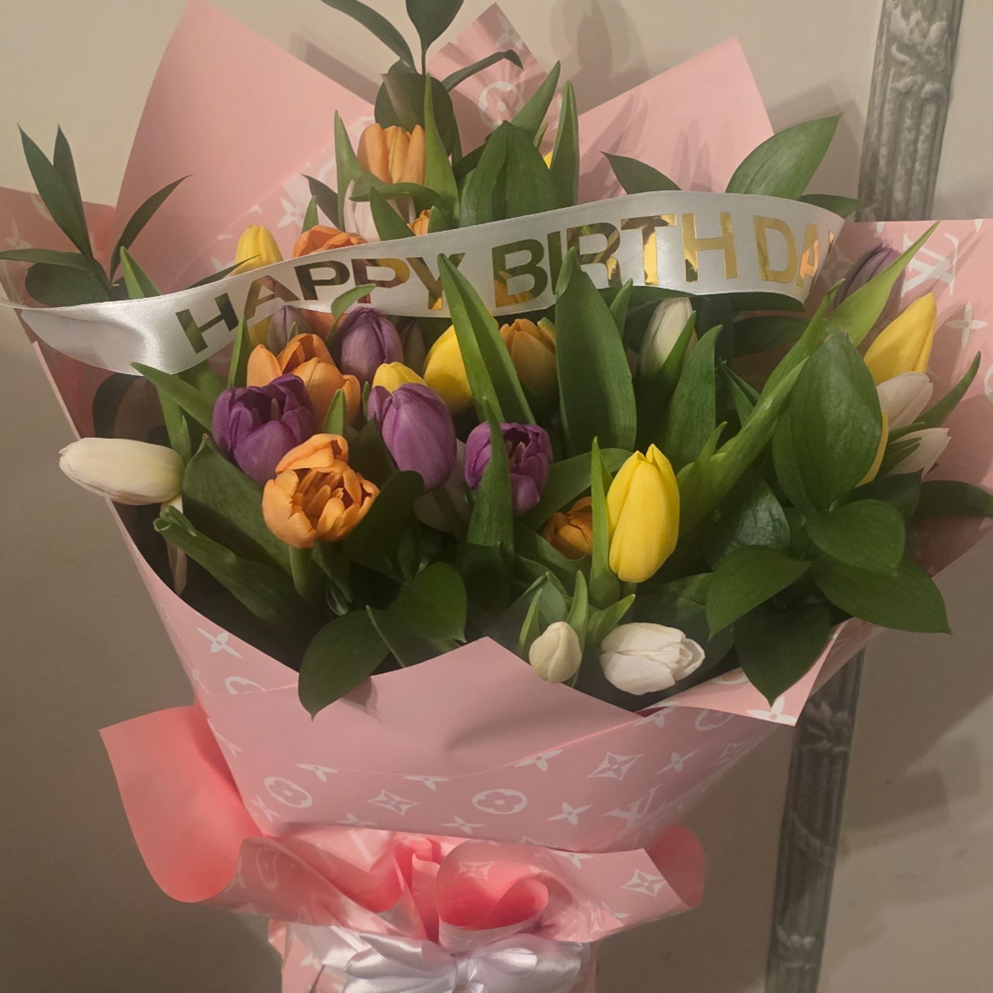 Bouquet of multicolored tulips wrapped in pink paper with a birthday ribbon, photo 2 of 4
