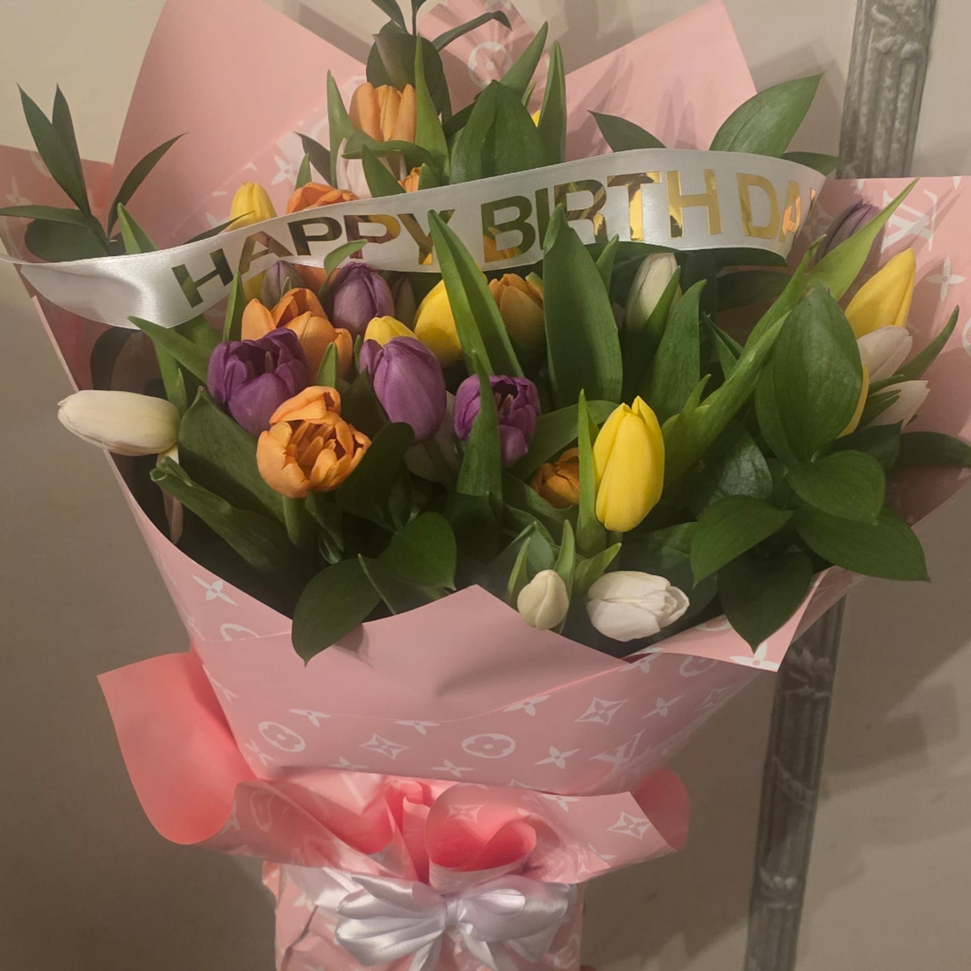 Bouquet of multicolored tulips wrapped in pink paper with a birthday ribbon, photo 4 of 4