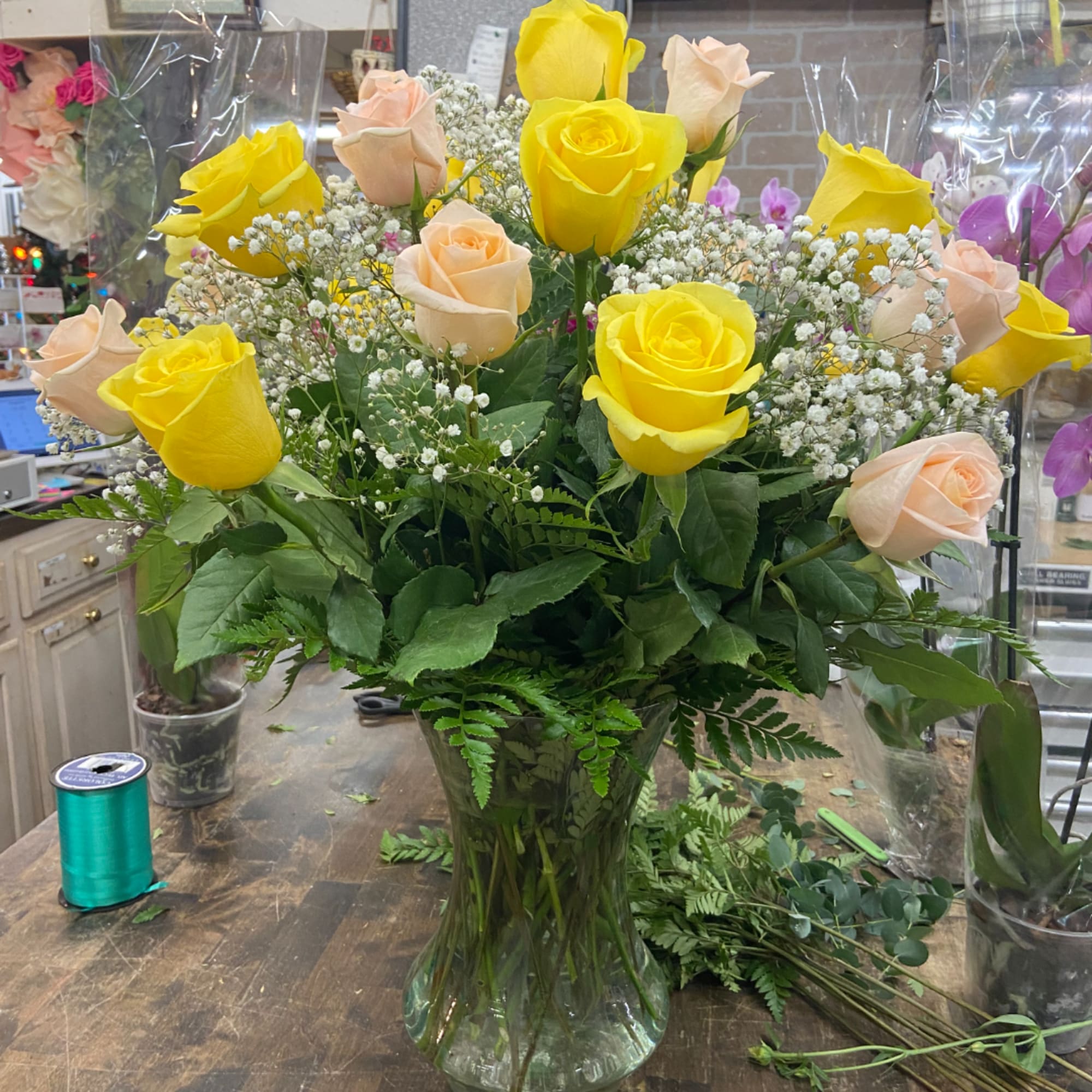 Bouquet of yellow and peach roses in a clear glass vase