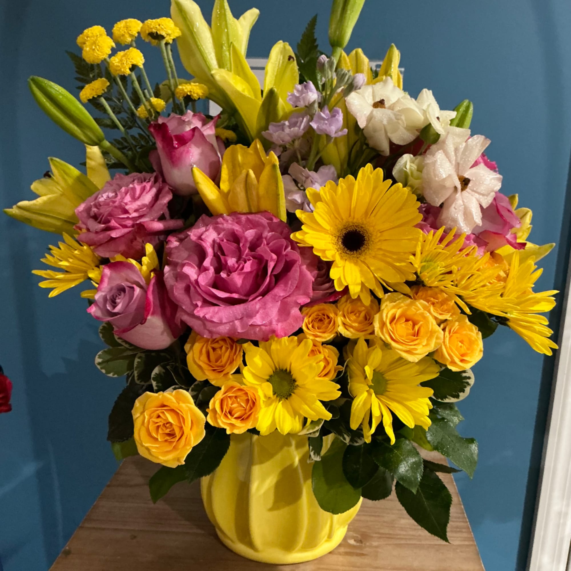 Mixed bouquet in a yellow vase with pink, yellow, and white flowers