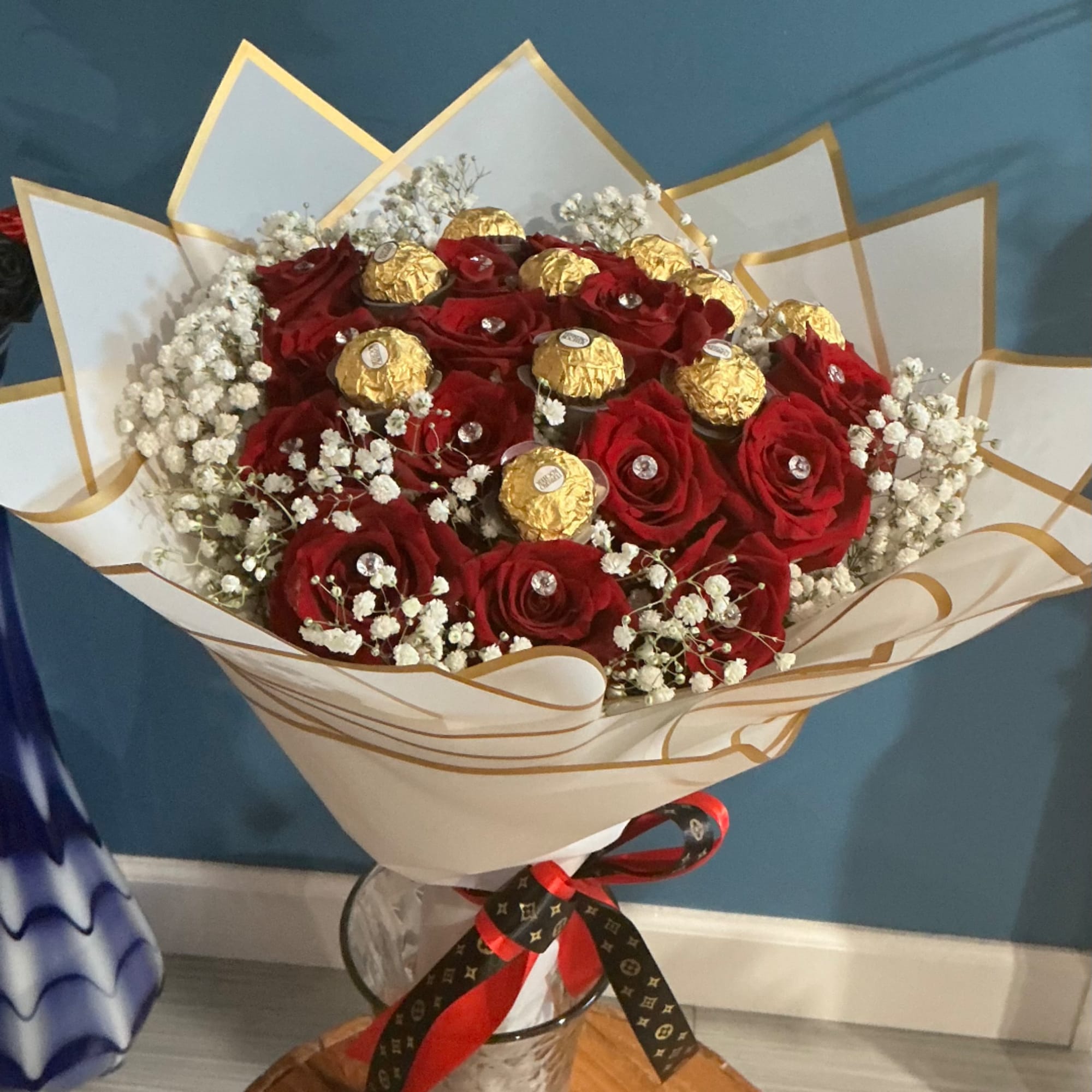 Bouquet of red roses with gold-wrapped chocolates in a clear vase, photo 4 of 4
