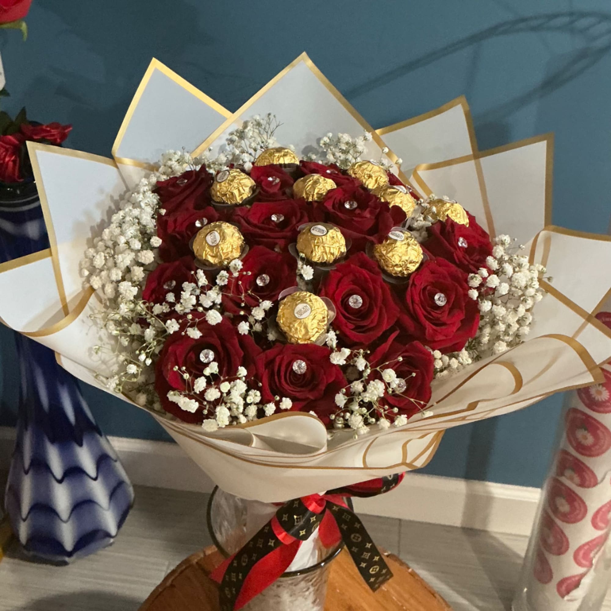 Bouquet of red roses with gold-wrapped chocolates in a clear vase, photo 3 of 4