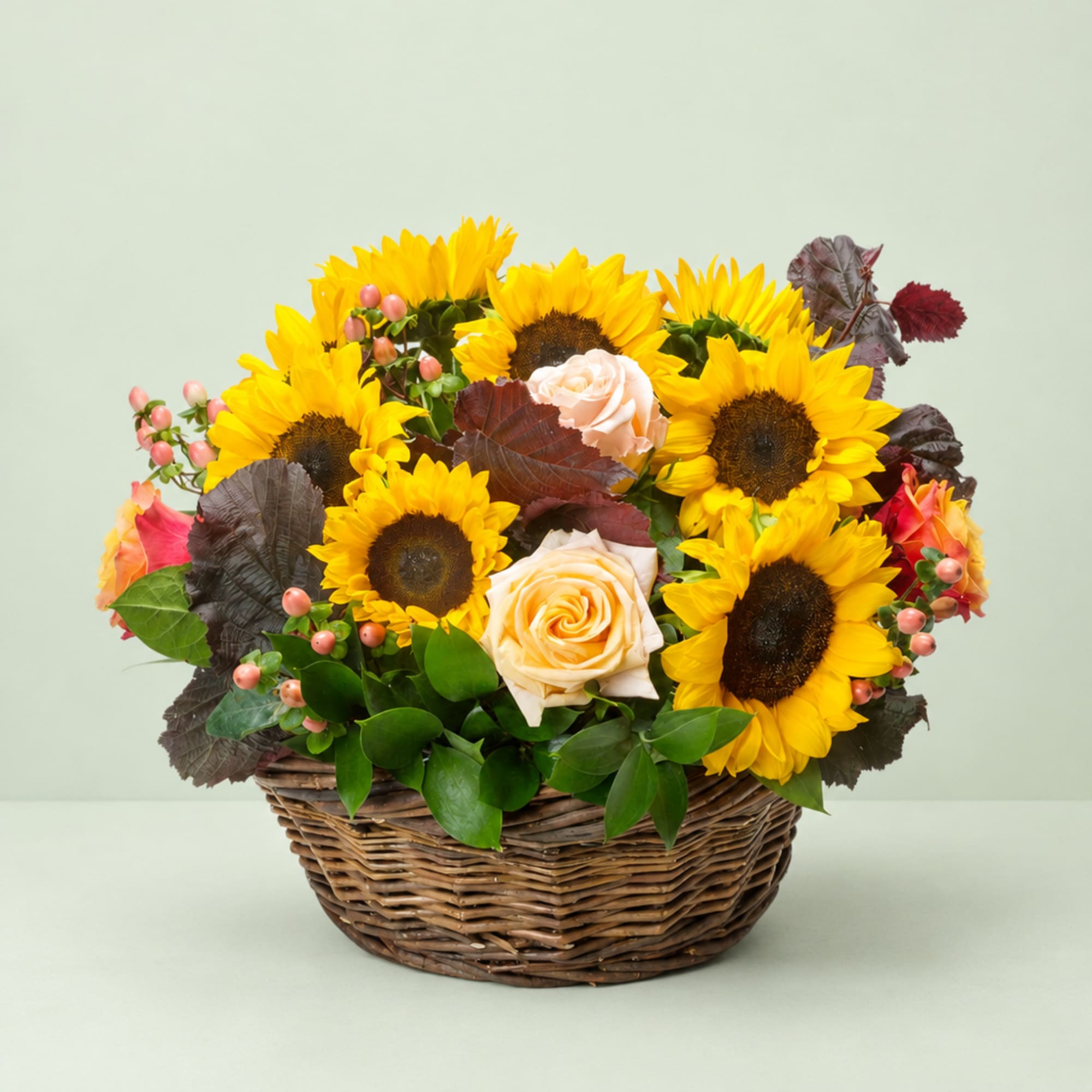Basket arrangement of sunflowers and peach roses