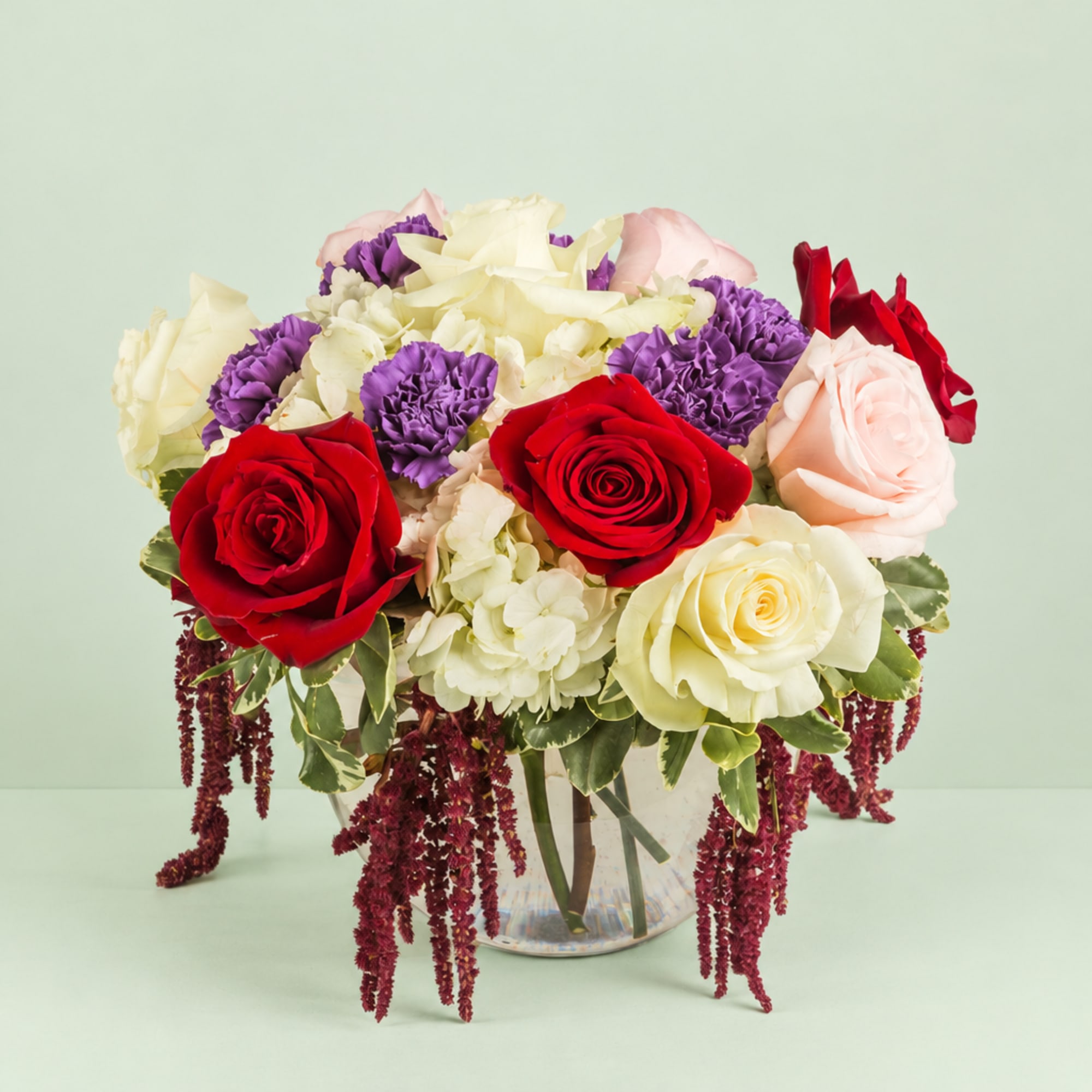 Bouquet of red, pink, white, and purple flowers in a clear glass vase