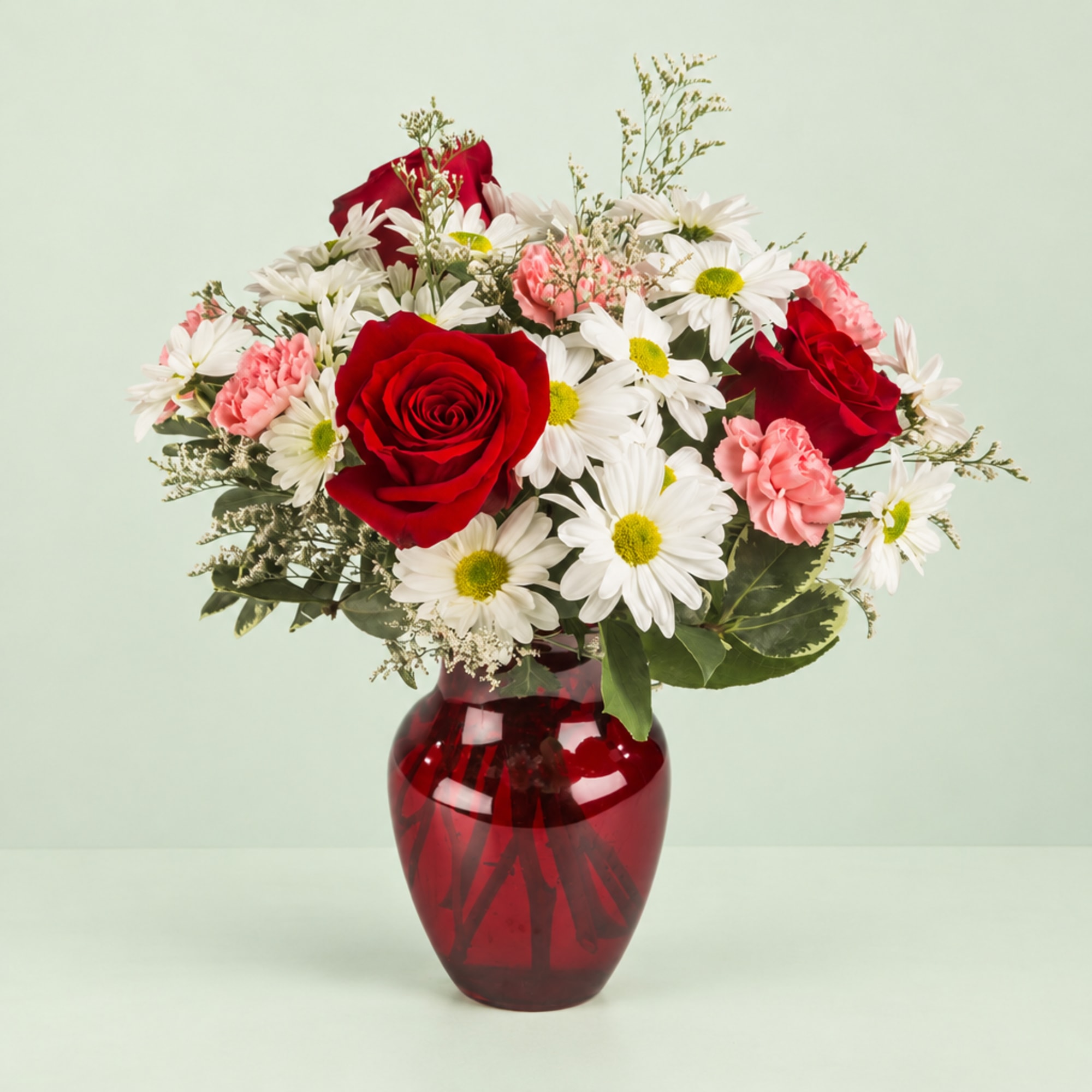 Red roses and white daisies in a red glass vase