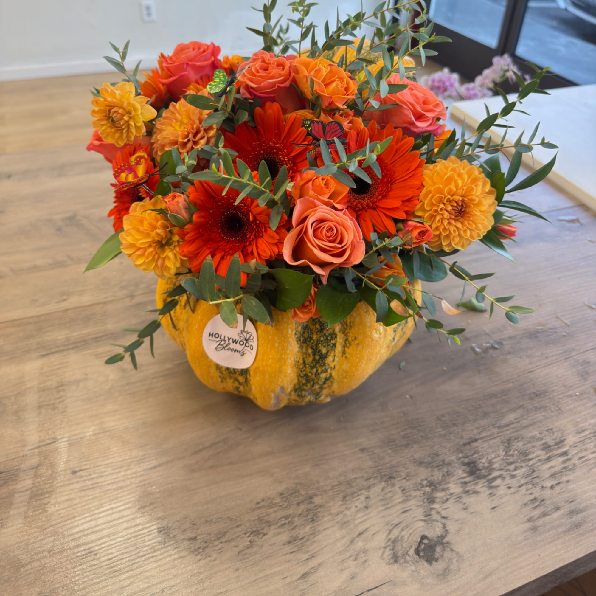 Orange and peach flower arrangement in a pumpkin container