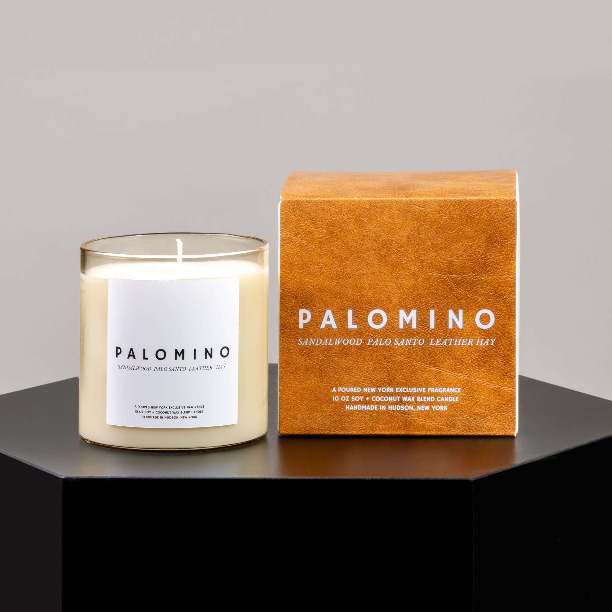Scented candle in a glass jar beside its orange box