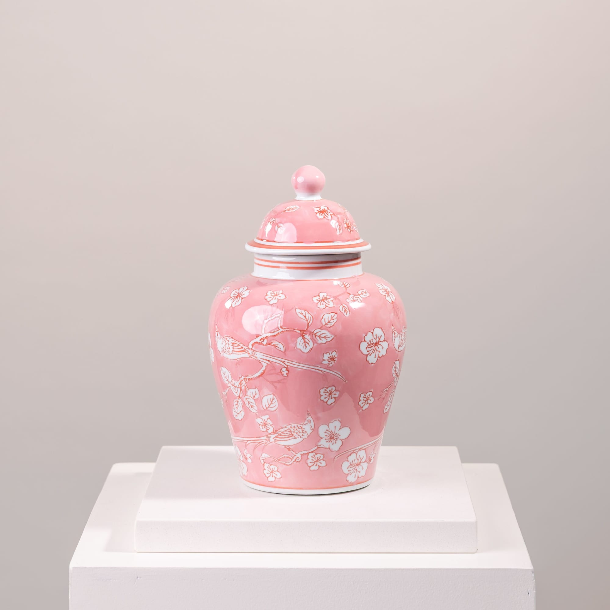 Pink ceramic lidded jar with white floral and bird pattern