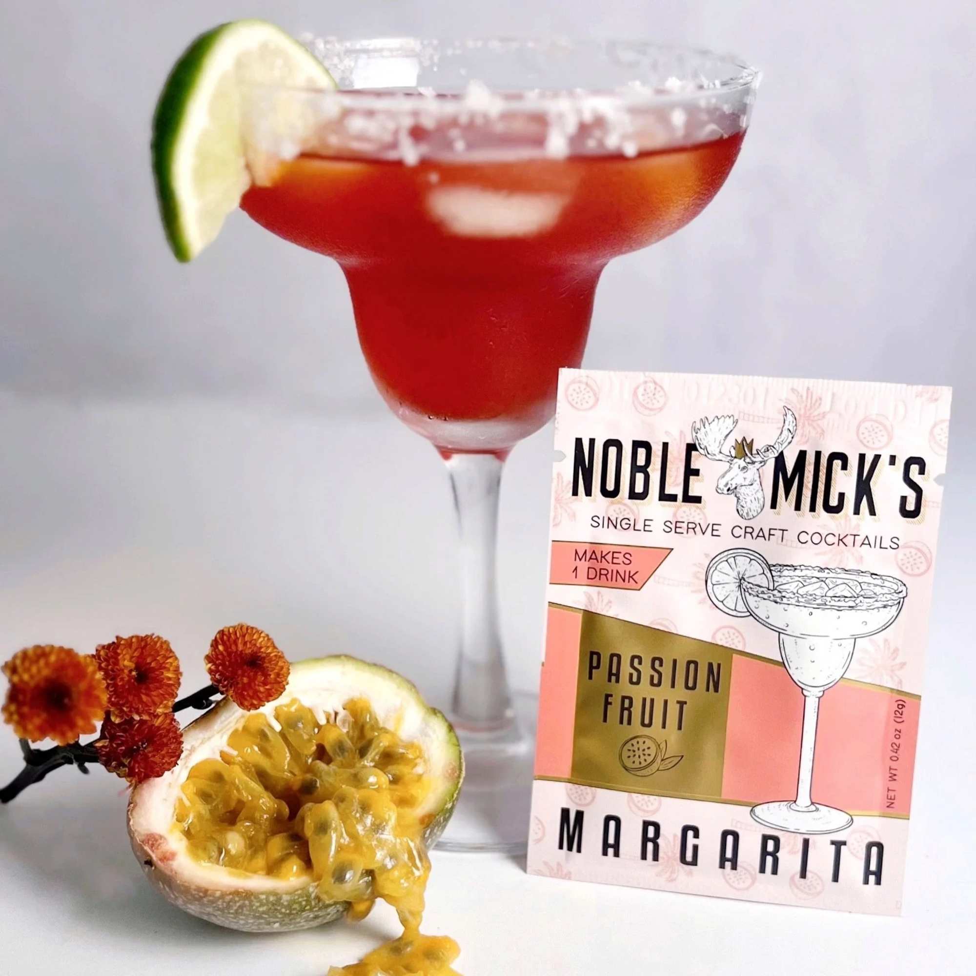 A margarita cocktail with a lime wedge and a passion fruit mix packet