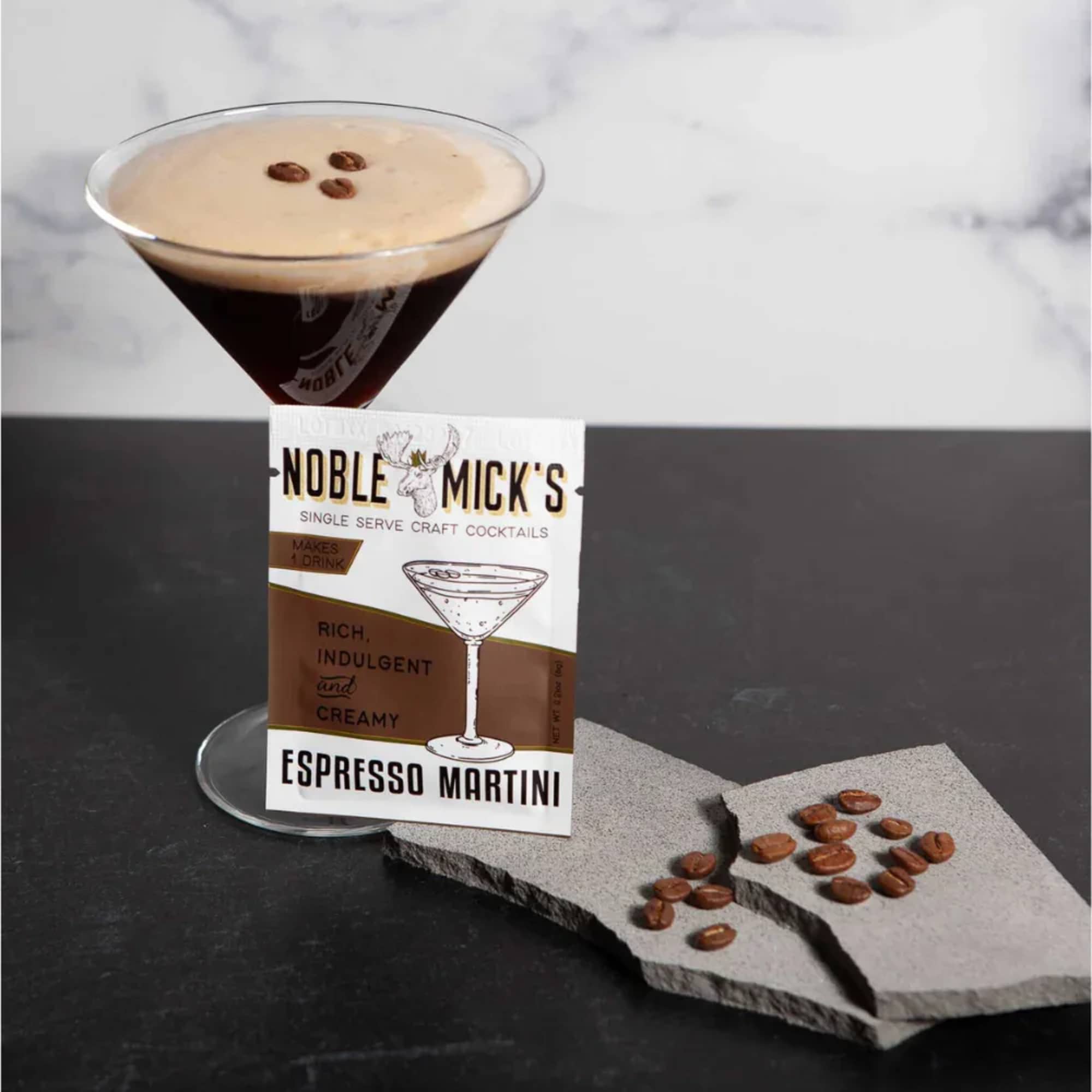 Espresso martini in a stemmed glass with coffee beans and a branded card