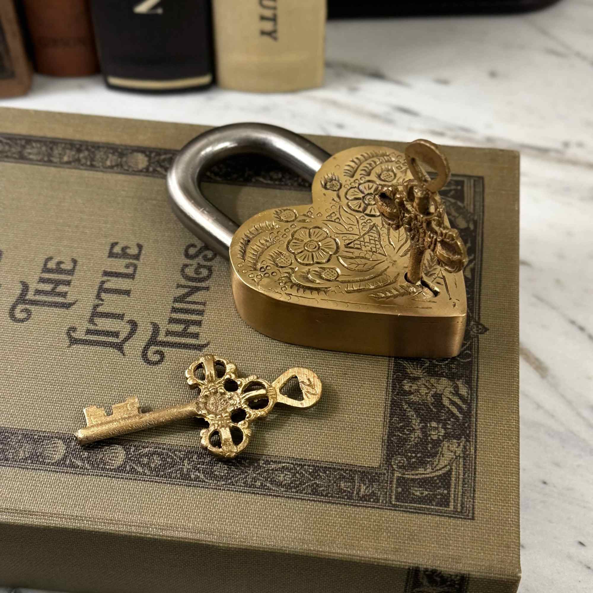 Heart-shaped brass padlock with a key on a decorative box